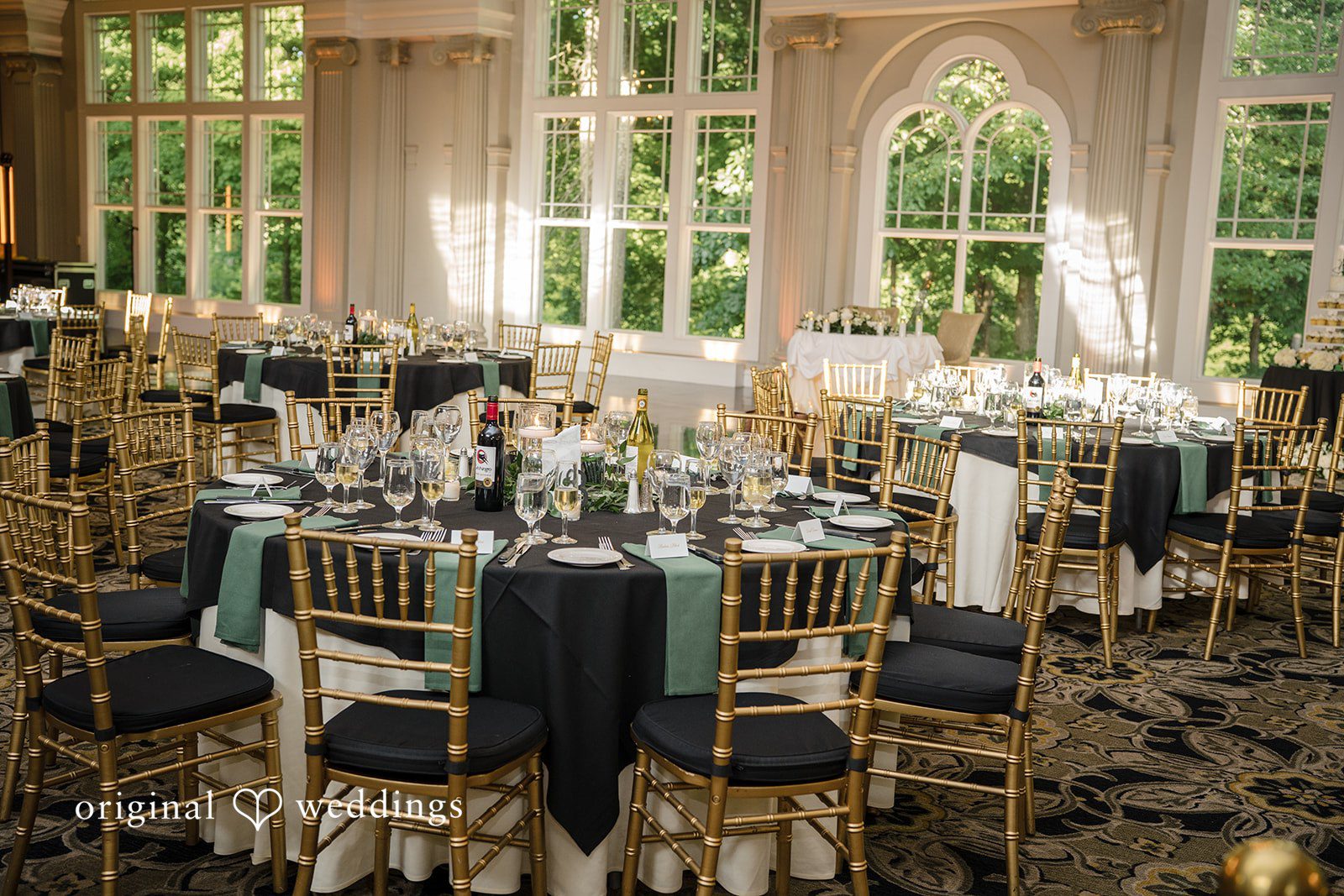 Kimberly + Jordan Beautifully decorated reception space with gold Chiavari chairs and round guest tables at The Riverview.