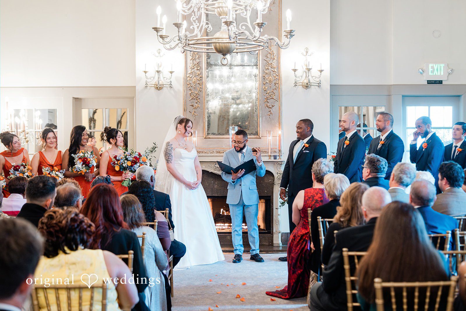 Madison + Malik Guests watching a wedding ceremony from their seats in a hall.