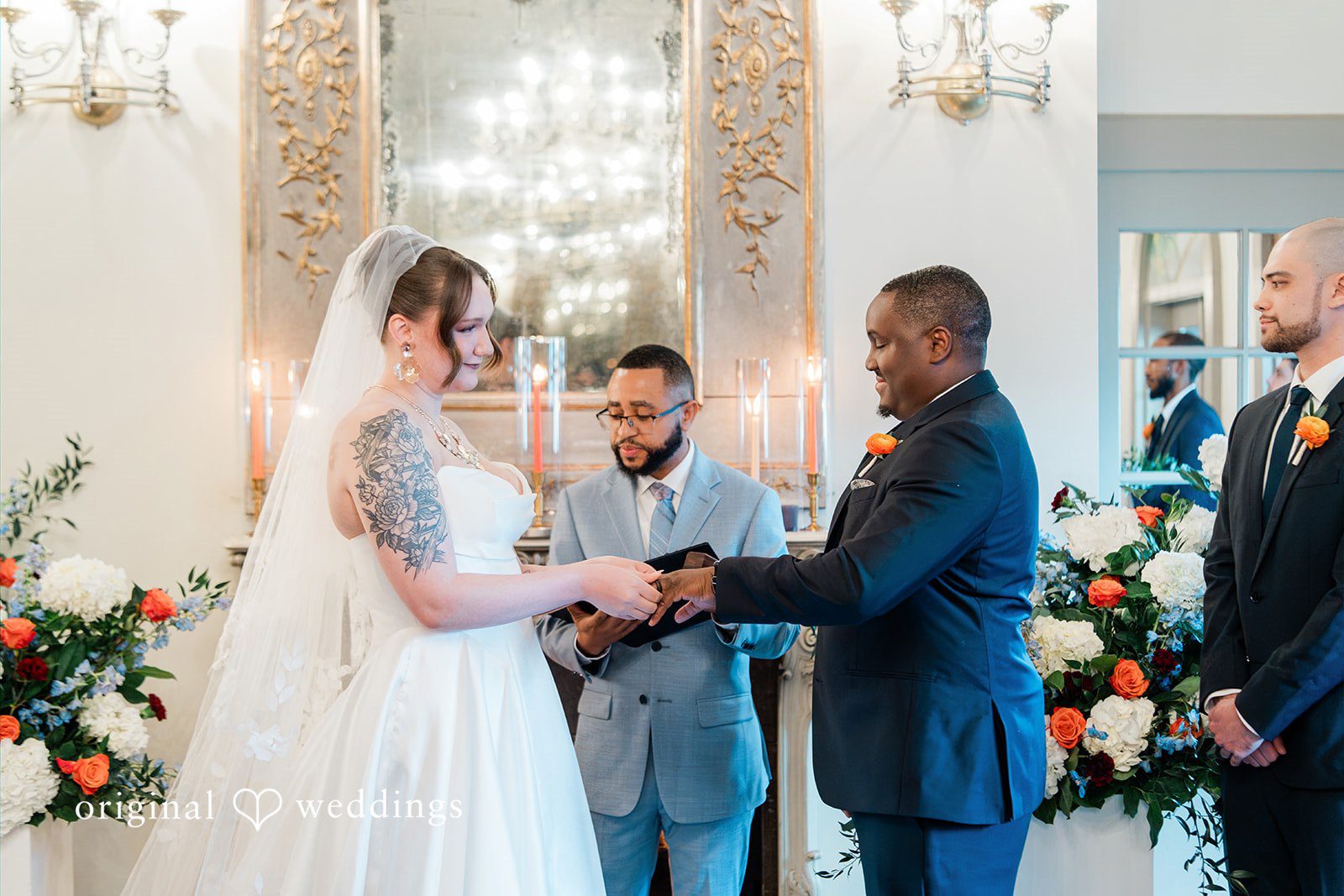Madison + Malik Bride and groom holding hands and exchanging ring during a wedding ceremony.