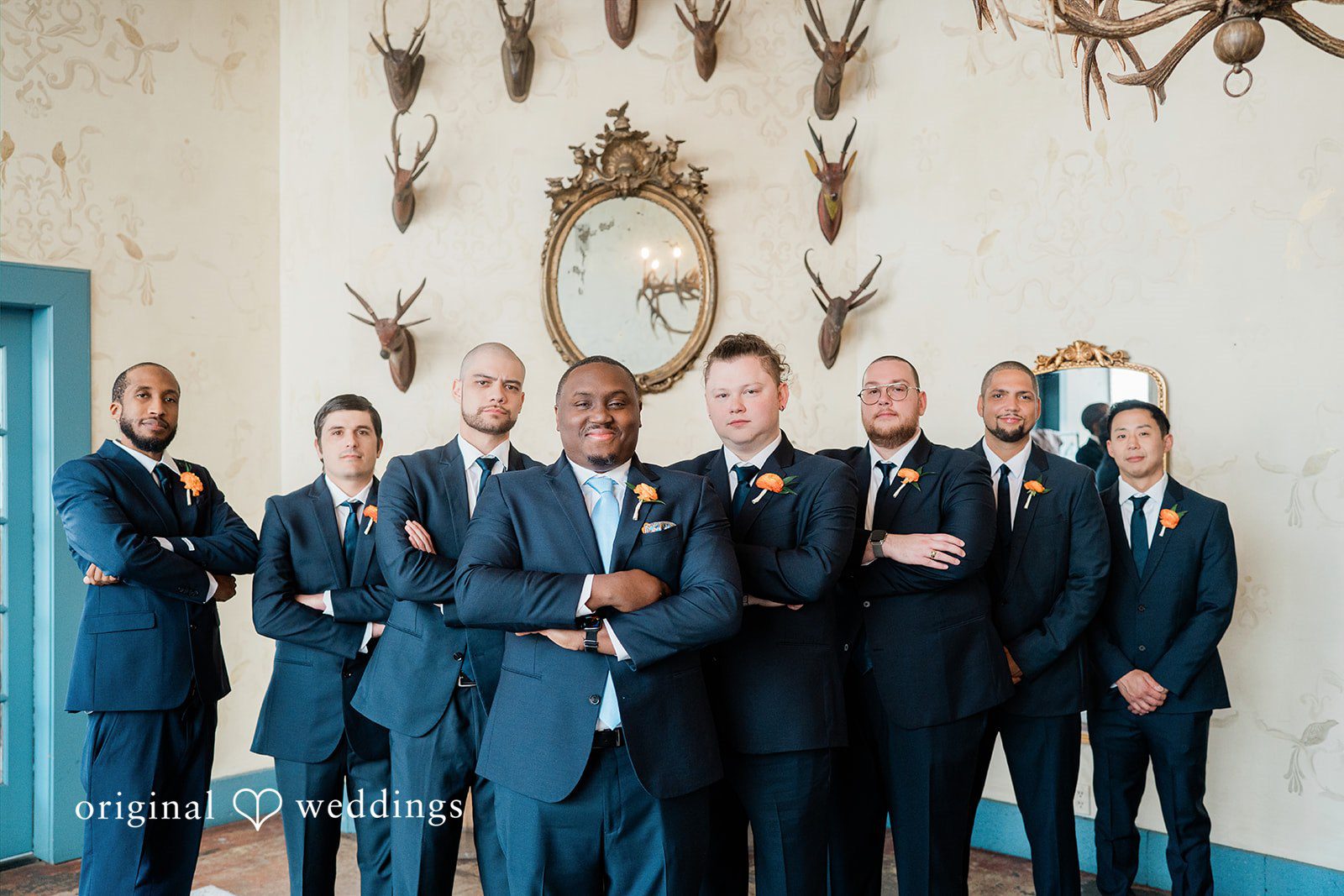 Madison + Malik Groom and groomsmen posing together in matching dark suits.