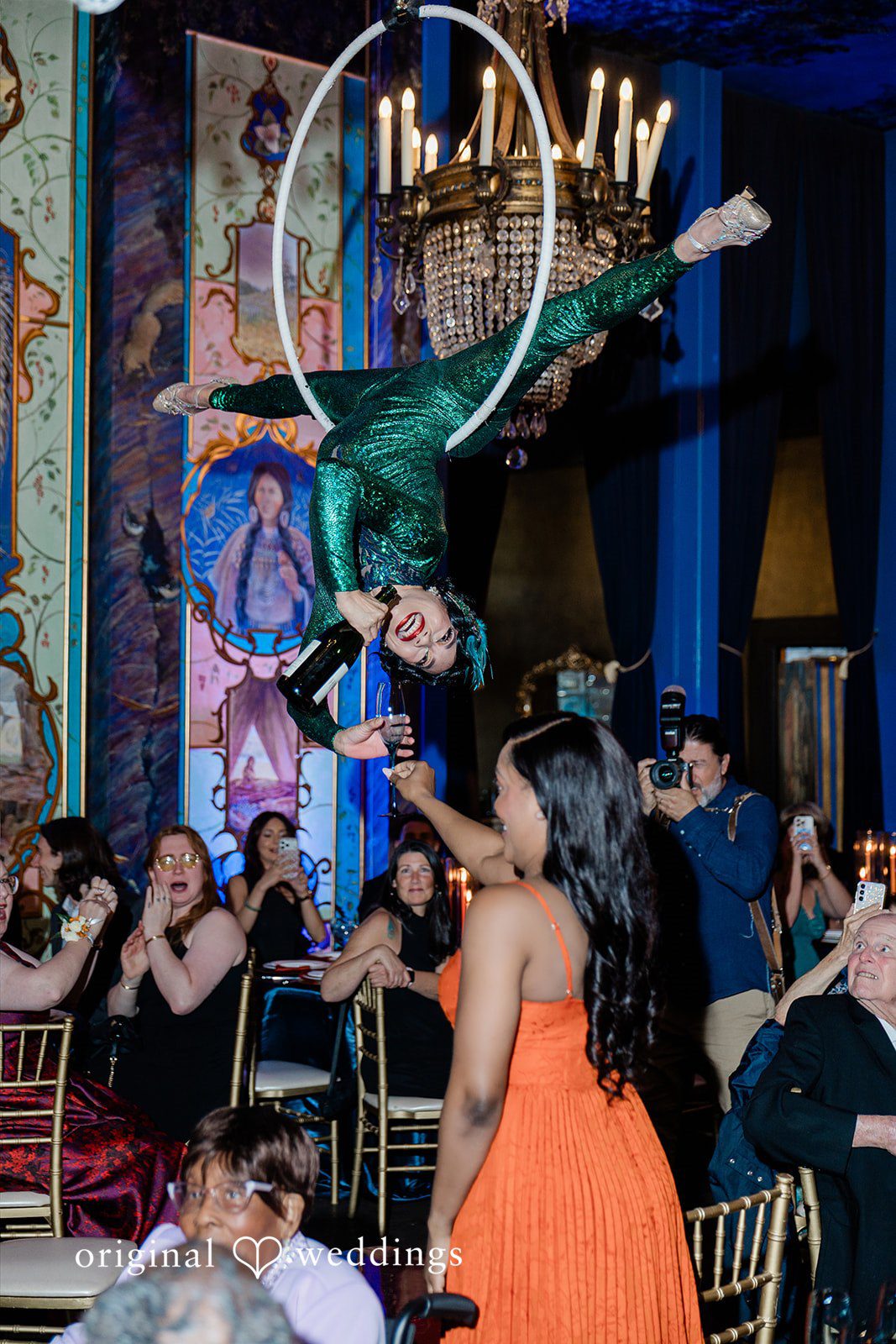 Madison + Malik An aerial acrobat performing on a hoop above guests at a reception.