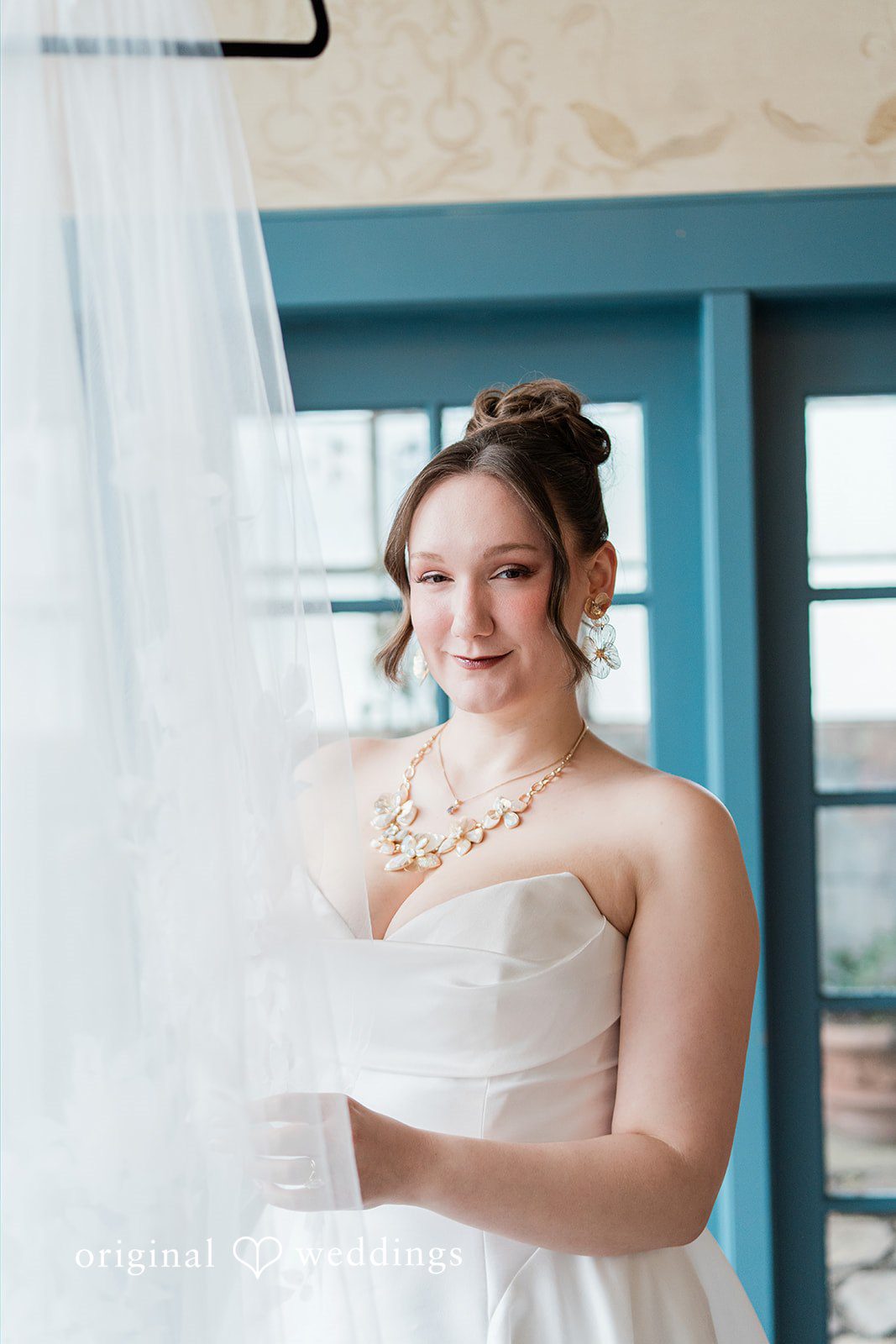 Madison + Malik A close-up portrait of a bride looking through a sheer white veil.