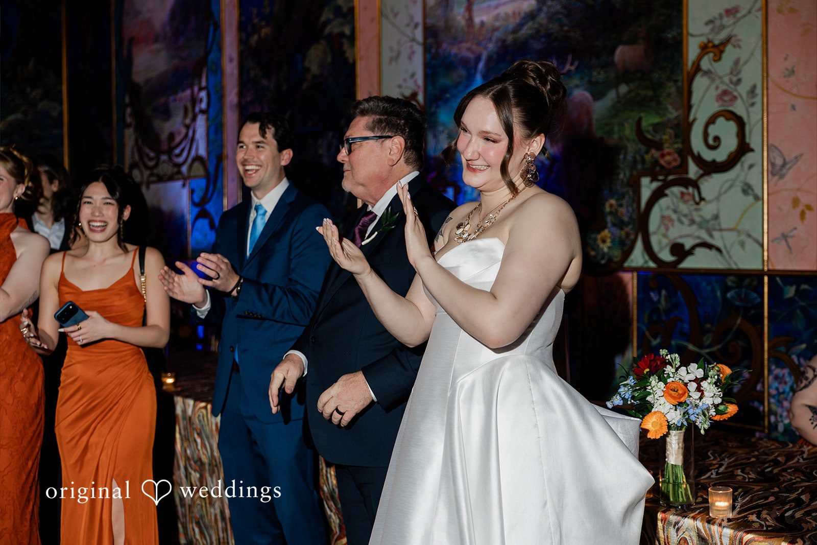 Madison + Malik A bride laughing and clapping alongside guests on the dance floor.