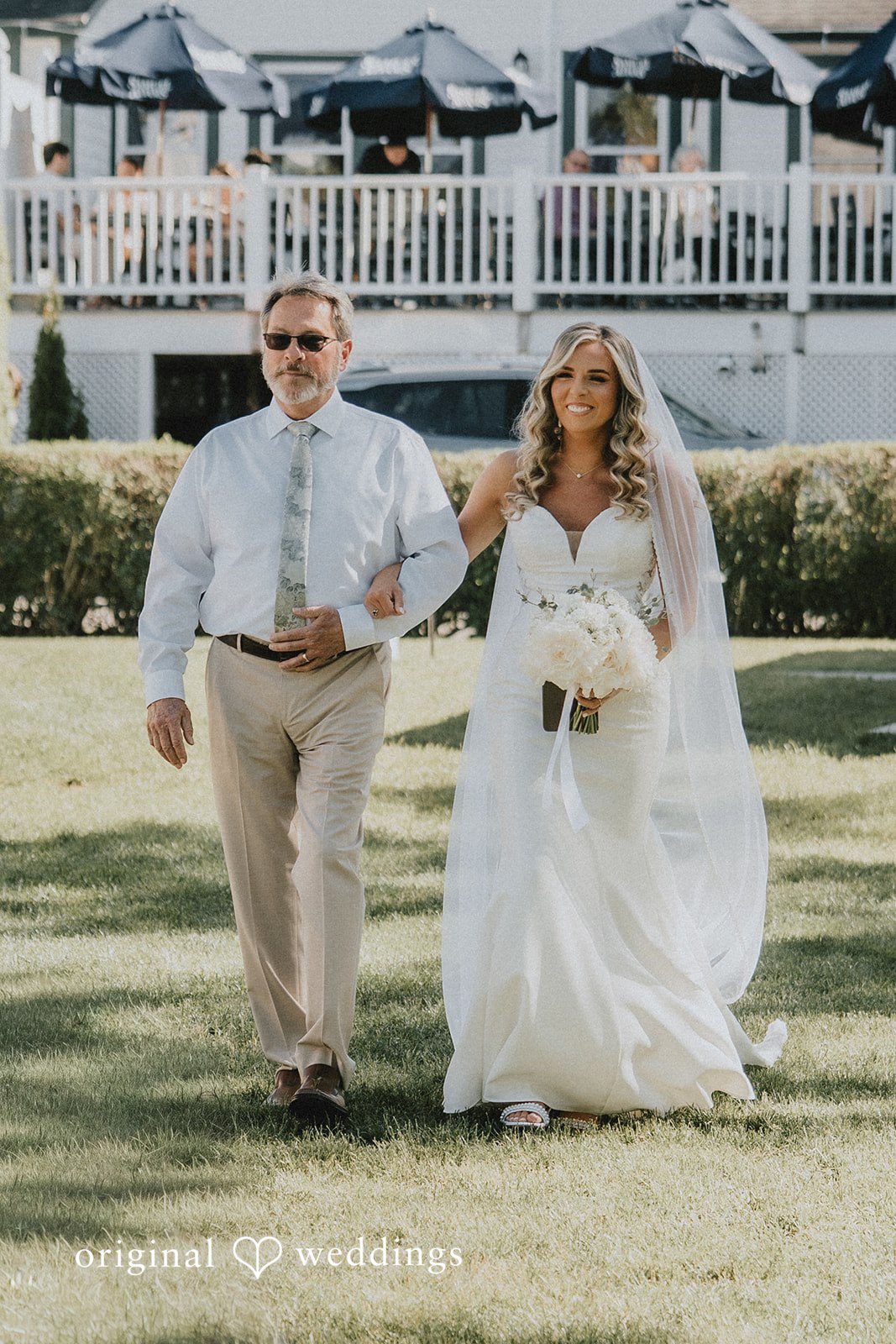 Kaylee + Raul A bride and man walking down a wide grassy wedding aisle.