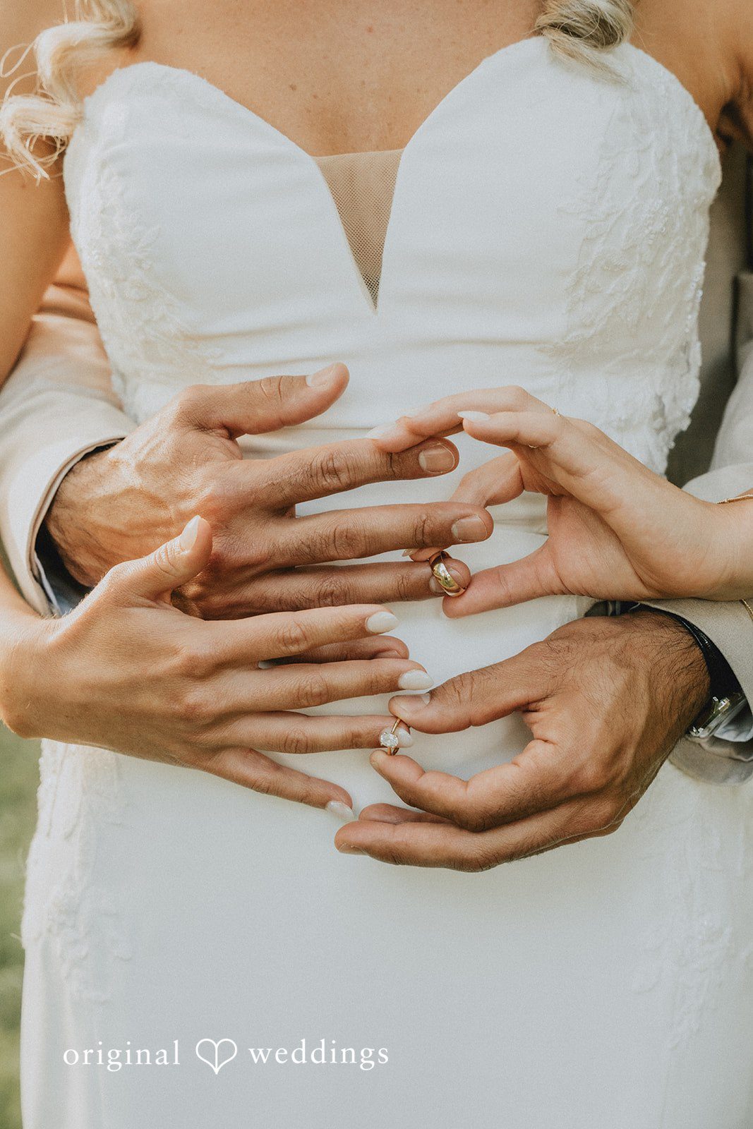 Kaylee + Raul Close-up of a bride and groom's hands clasped together and exchanging rings .