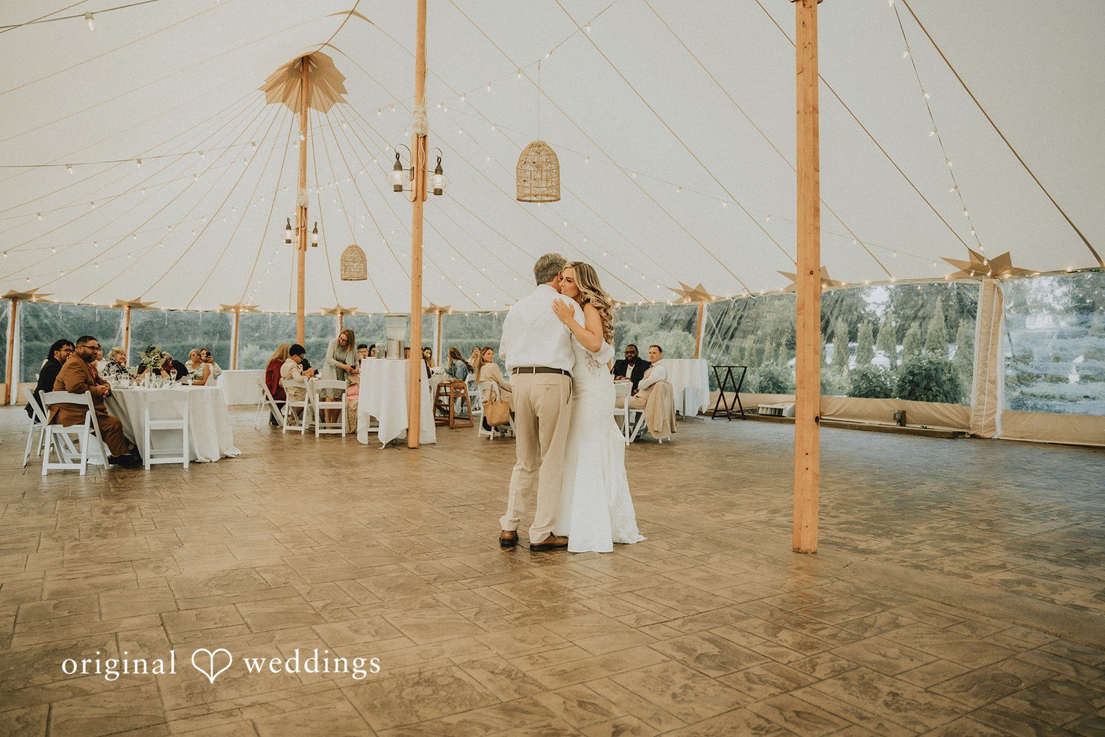 Kaylee + Raul A wide shot of a bride and a man dancing in the center of a spacious wedding reception venue.