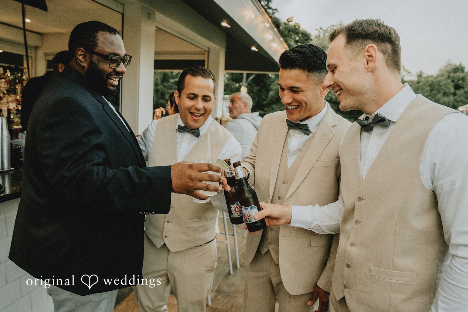 Kaylee + Raul A group of men standing together at a wedding reception while holding drinks.