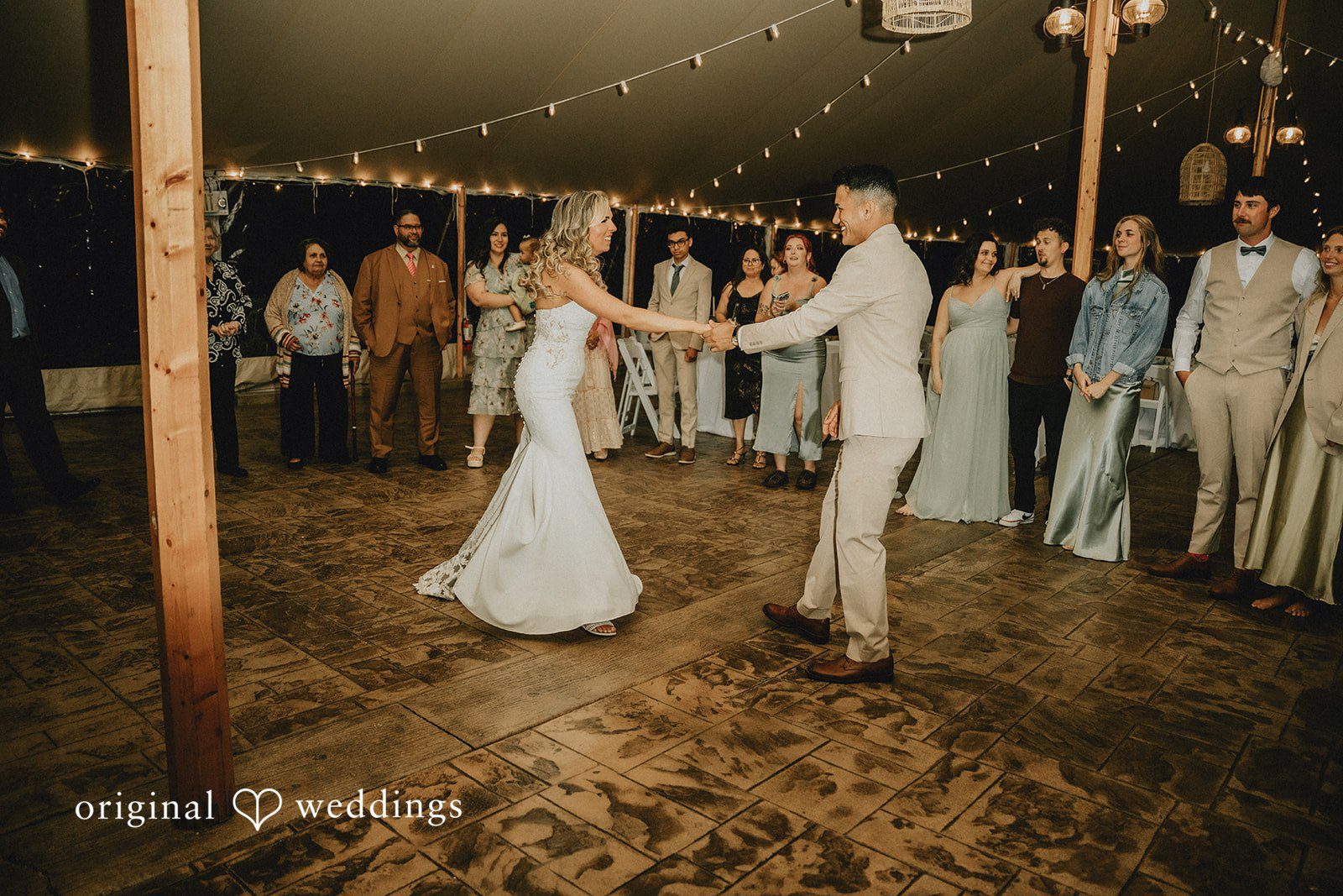 Kaylee + Raul A bride and groom dancing together on an active dance floor surrounded by wedding guests.