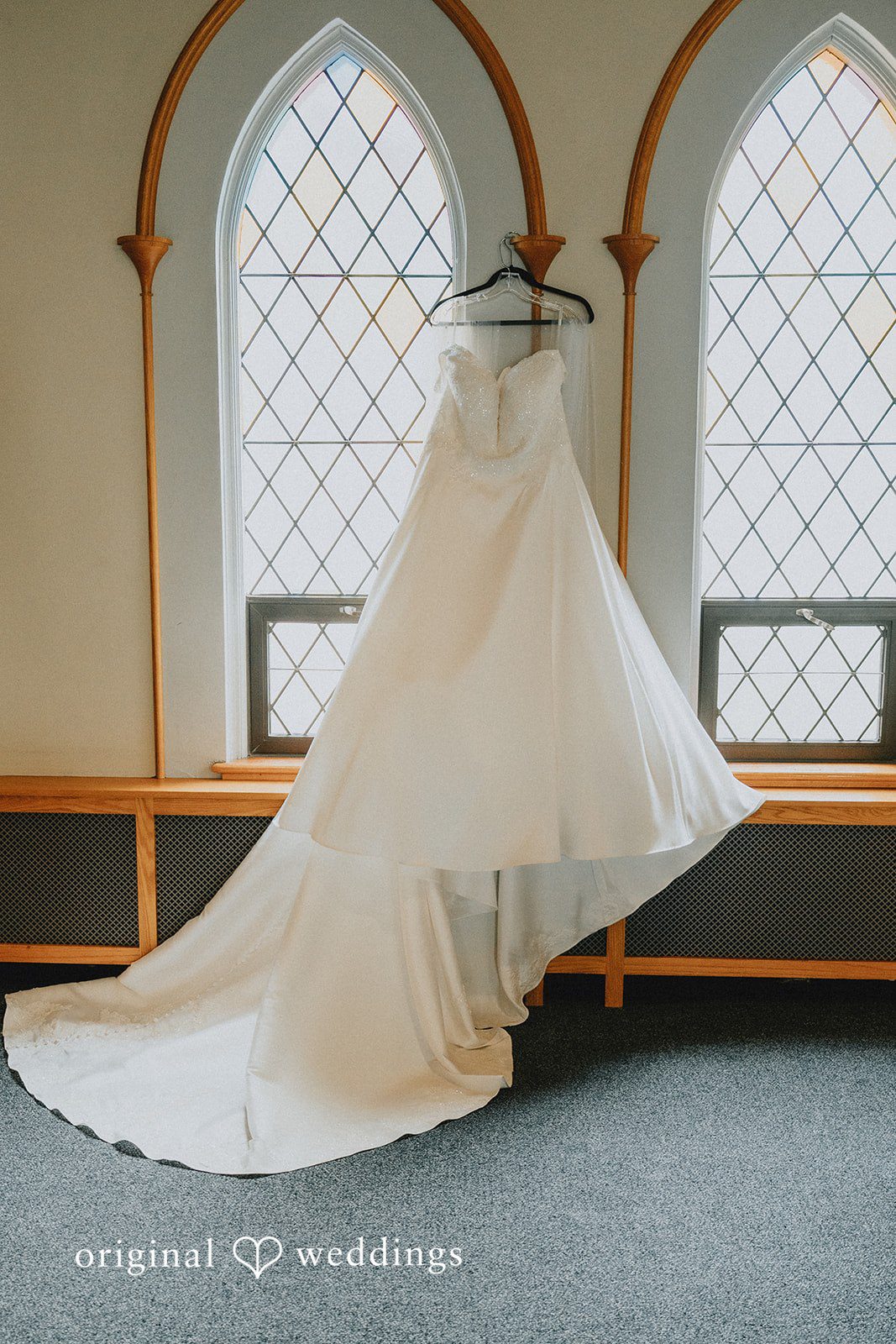 Kevin + Brooke Beautiful white wedding gown hang across a wall at The Seville