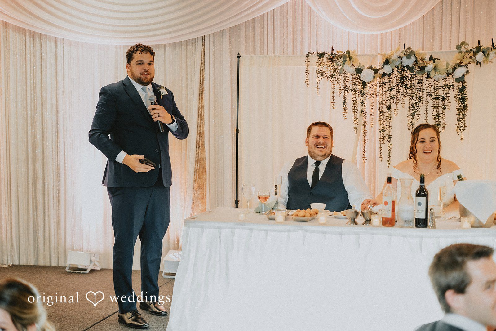 Kevin + Brooke Couple listening to the speech of a guest at wedding reception