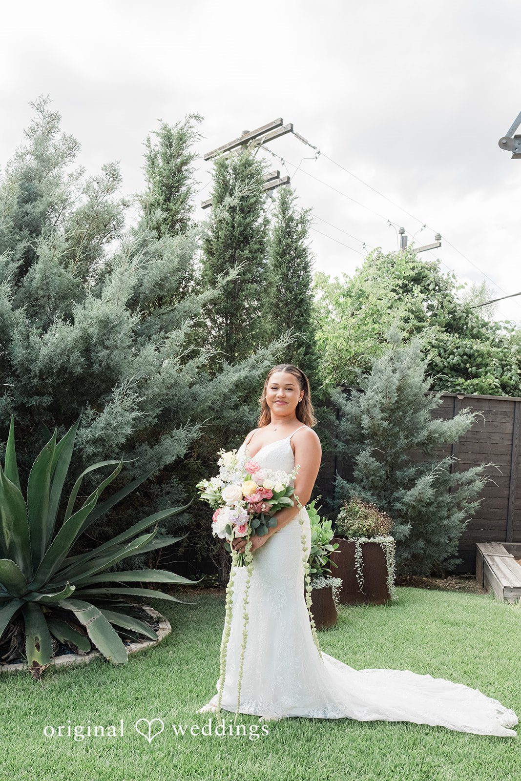 Lilly + Cade Bride smiling while holding her beautiful bouquet at The Terrace Club.