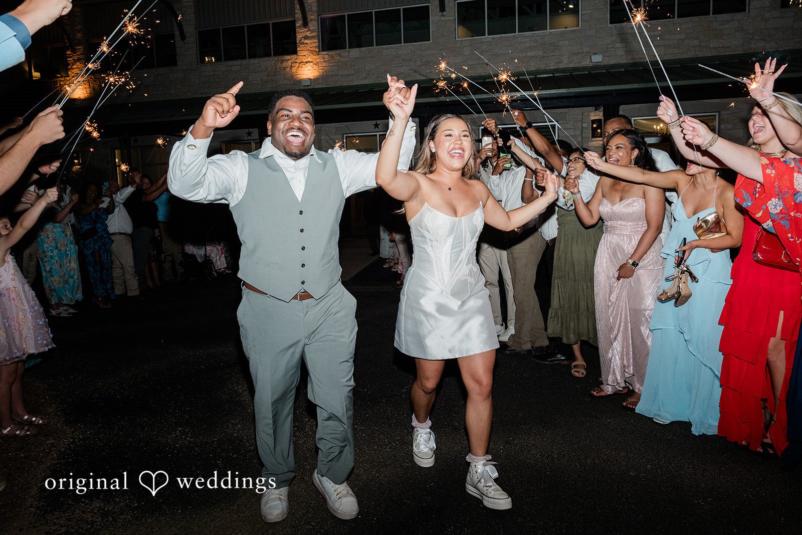 Lilly + Cade Bride and groom celebrating during their sparkler exit at The Terrace Club captured by Austin Wedding Photographers from Original Weddings.