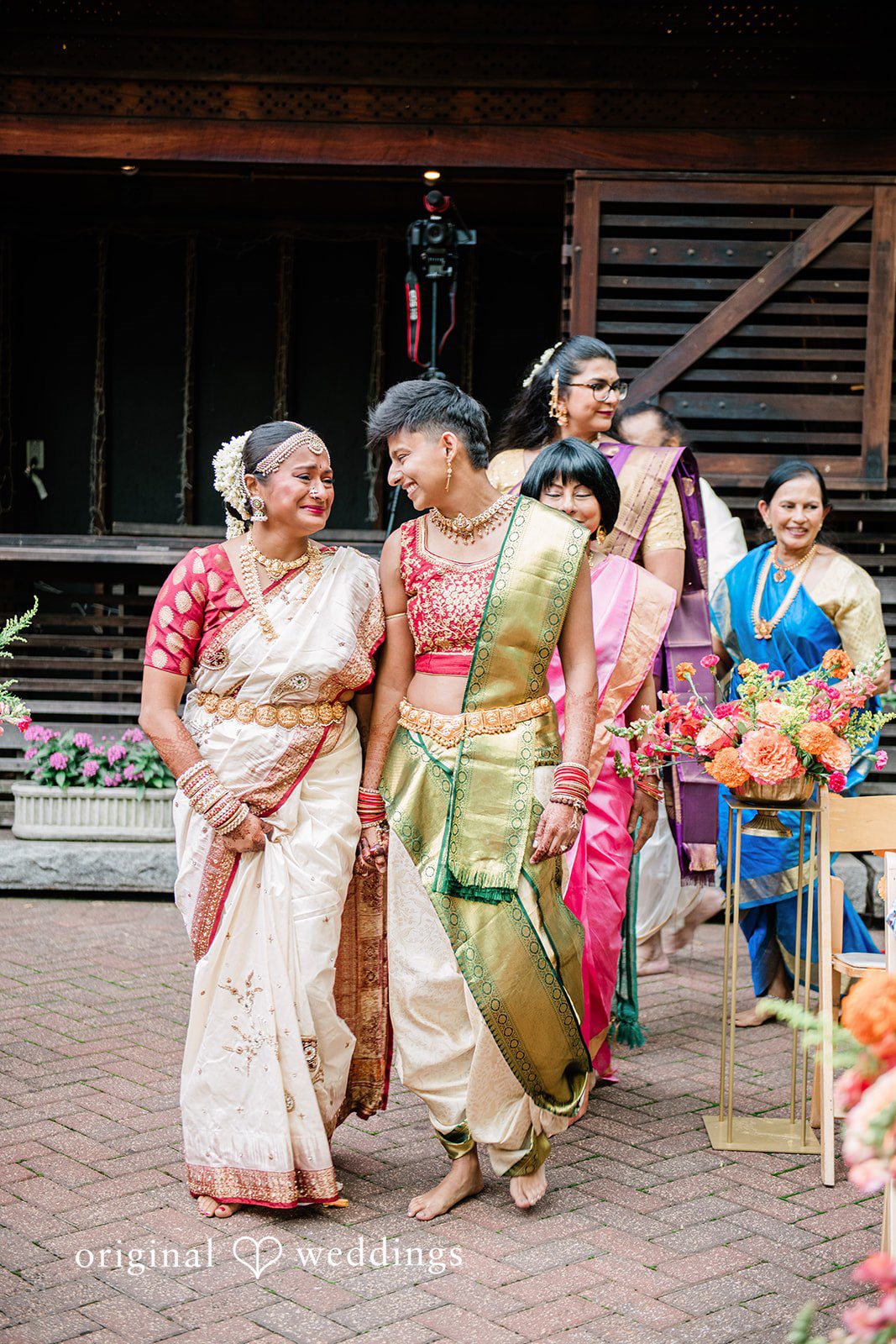 Sonya + Akshaya A bride and groom walking together while smiling at each other.