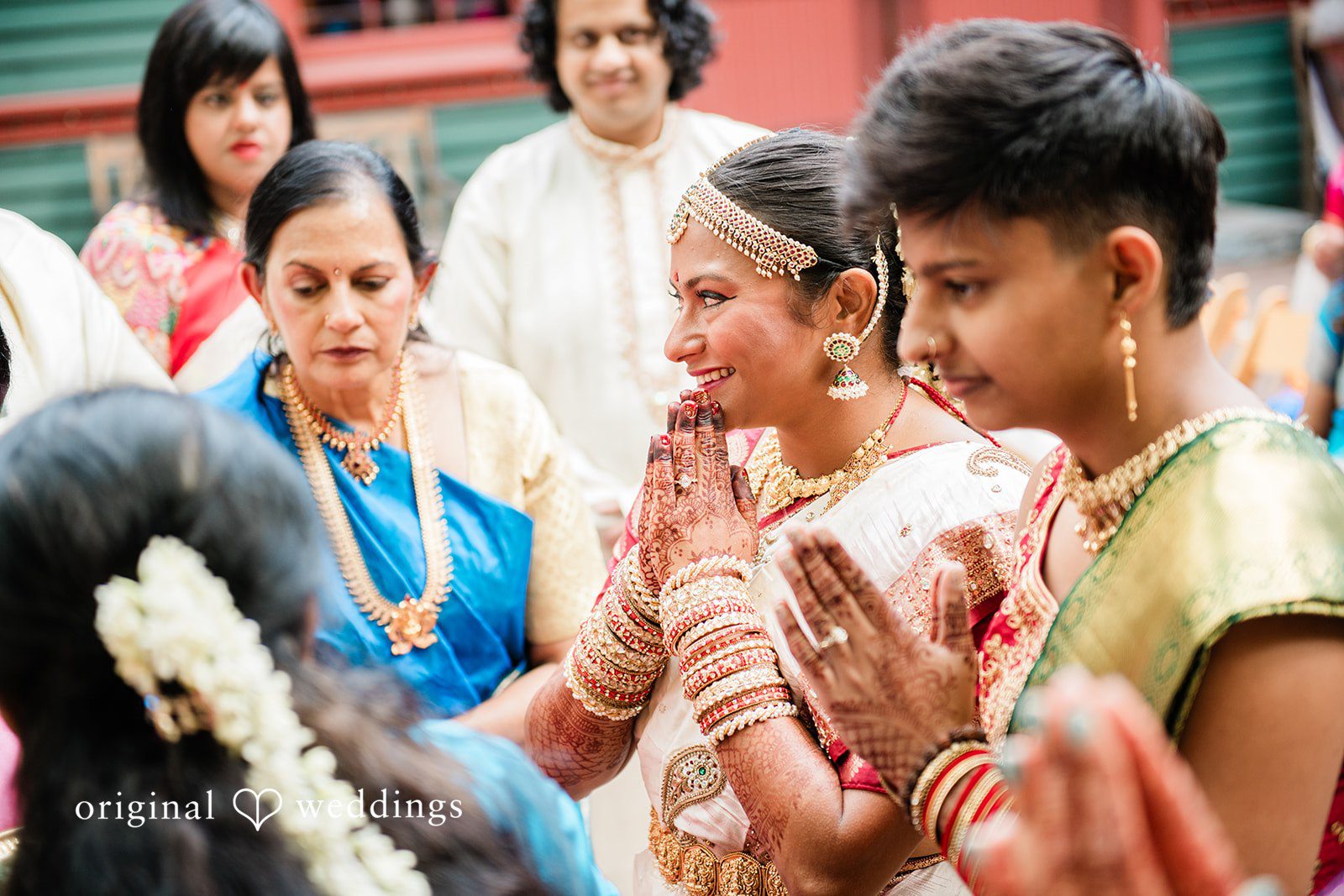 Sonya + Akshaya A close-up of a groom smiling while surrounded by wedding guests.
