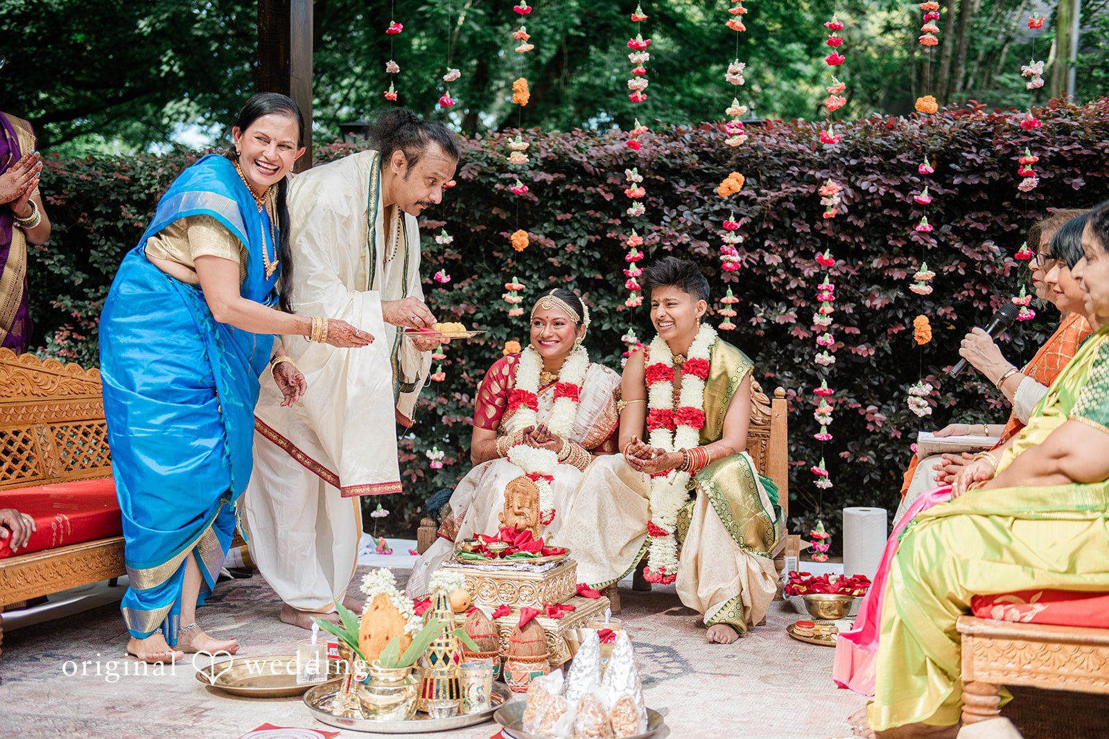 Sonya + Akshaya A couple participating in traditional wedding rituals during a ceremony with family.