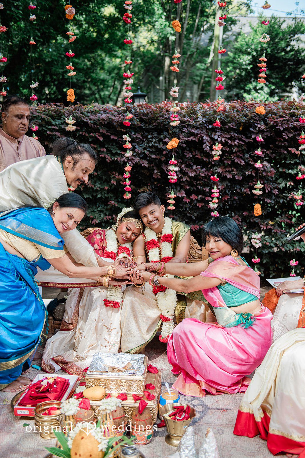 Sonya + Akshaya Family members surrounding a seated couple during a traditional wedding ritual.