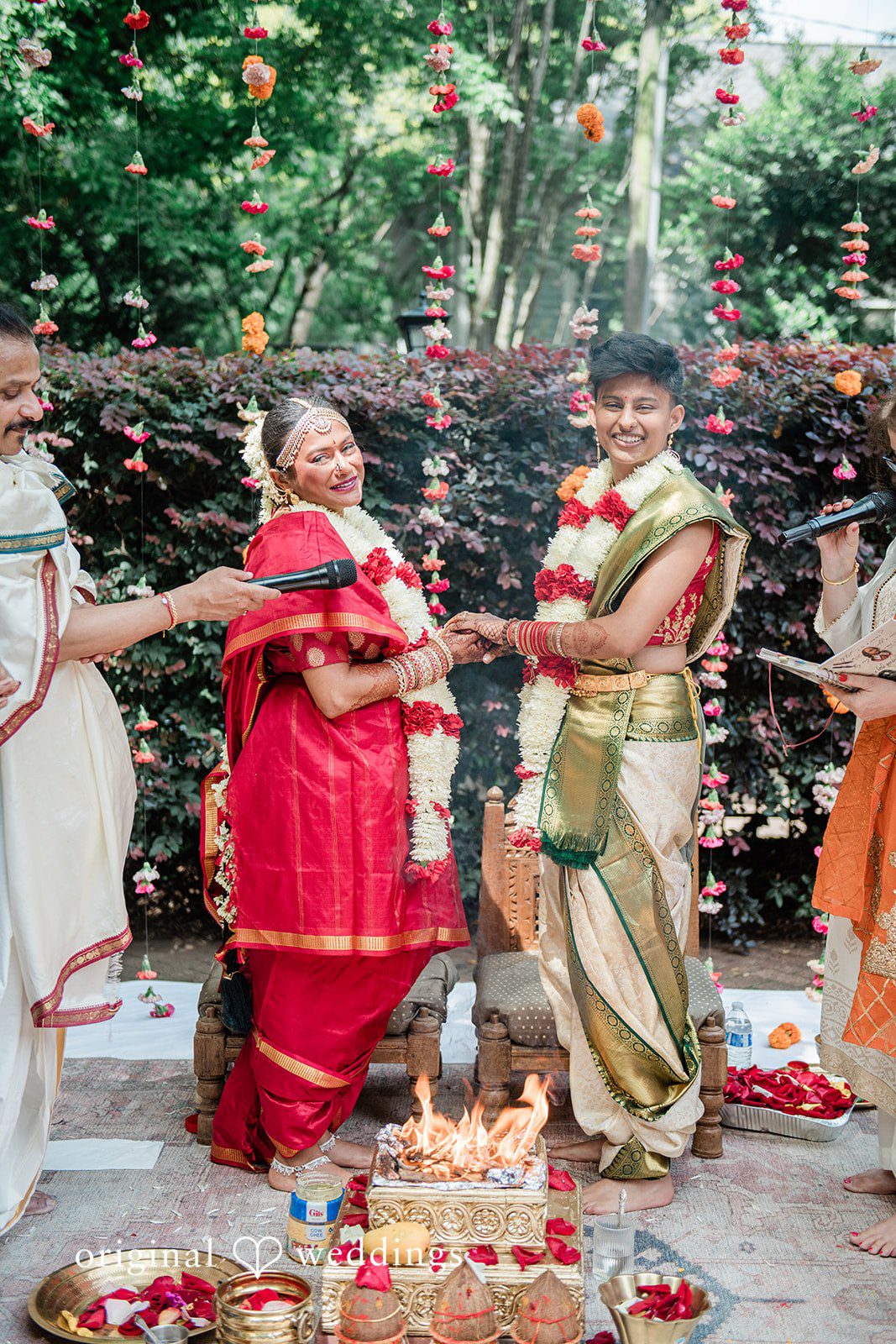 Sonya + Akshaya A couple holding hands during their traditional wedding ceremony.
