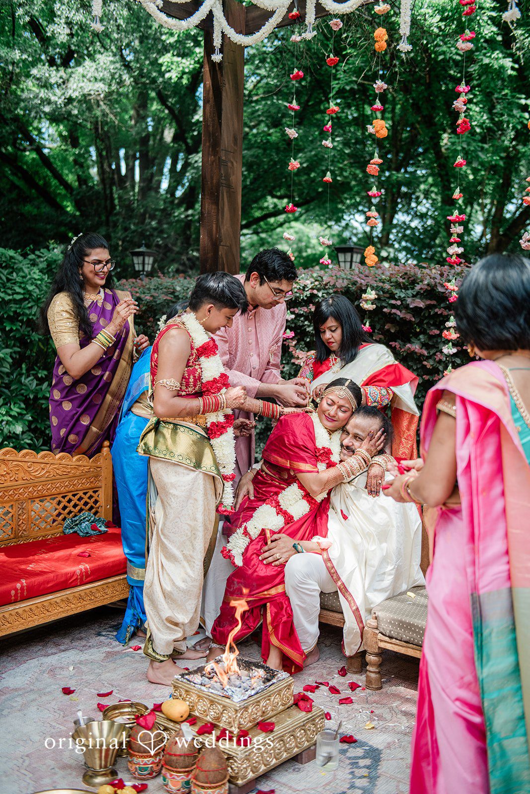 Sonya + Akshaya Guests gathered around a couple during a traditional wedding ceremony ritual.