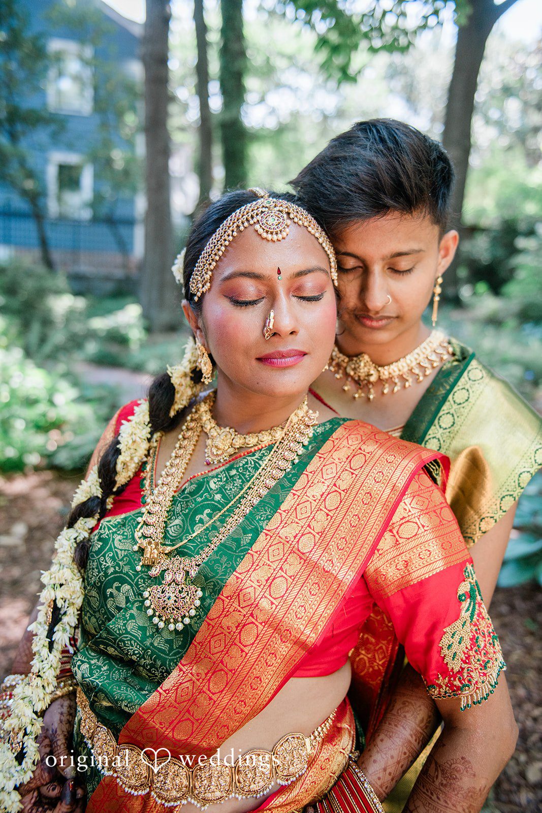 Sonya + Akshaya A groom embracing a bride with closed eyes from behind.