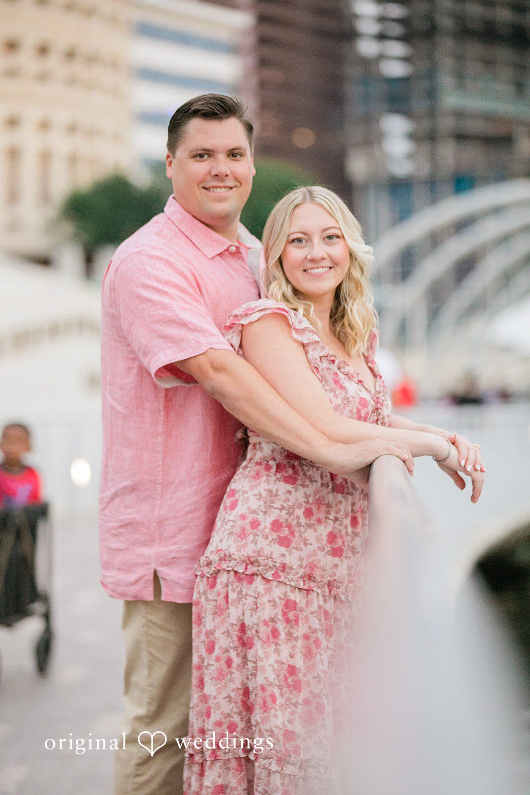 Taylor + Jack Man wrapping his arms around a woman leaning against a bridge railing.