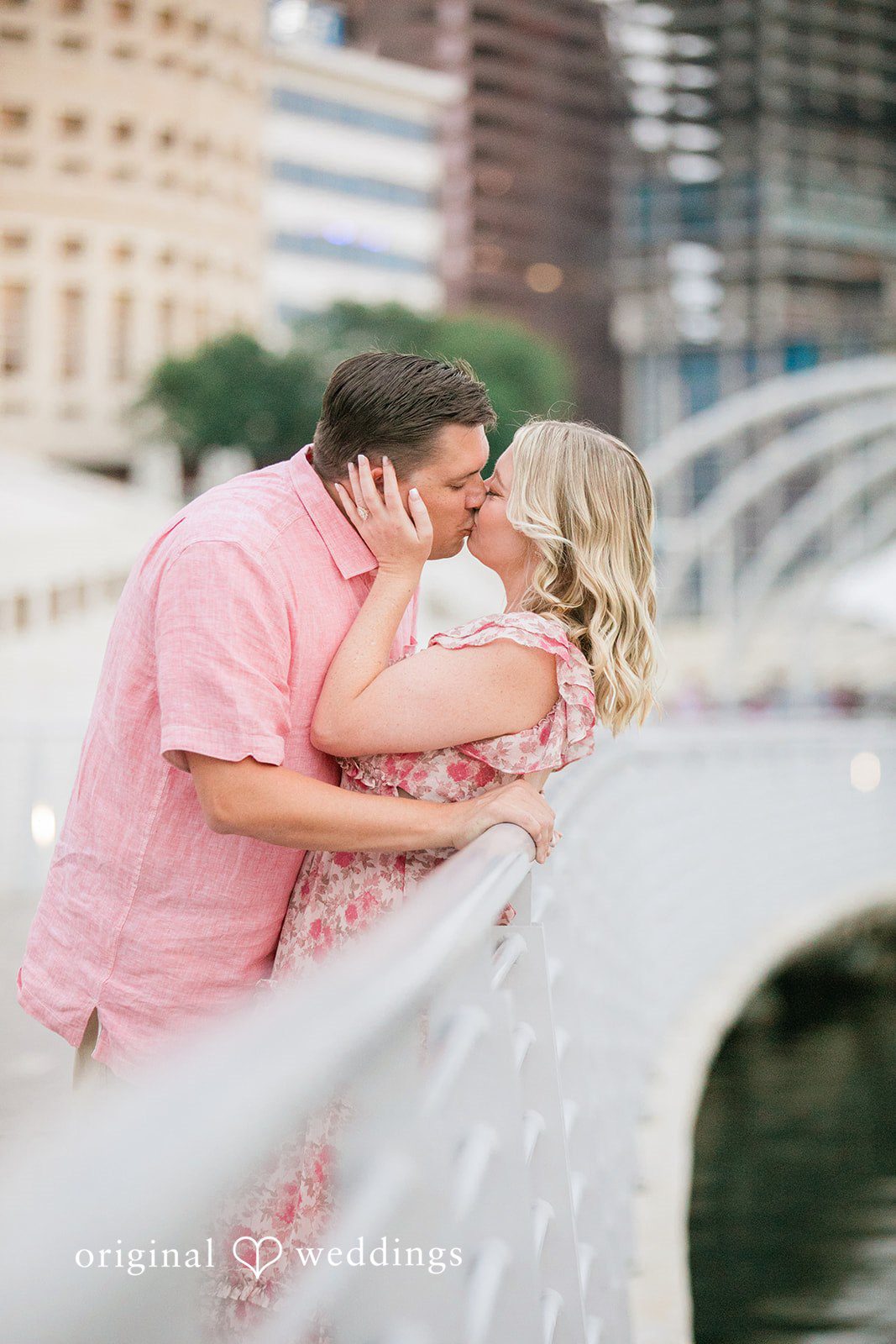 Taylor + Jack Couple kissing while leaning against a white pedestrian bridge.