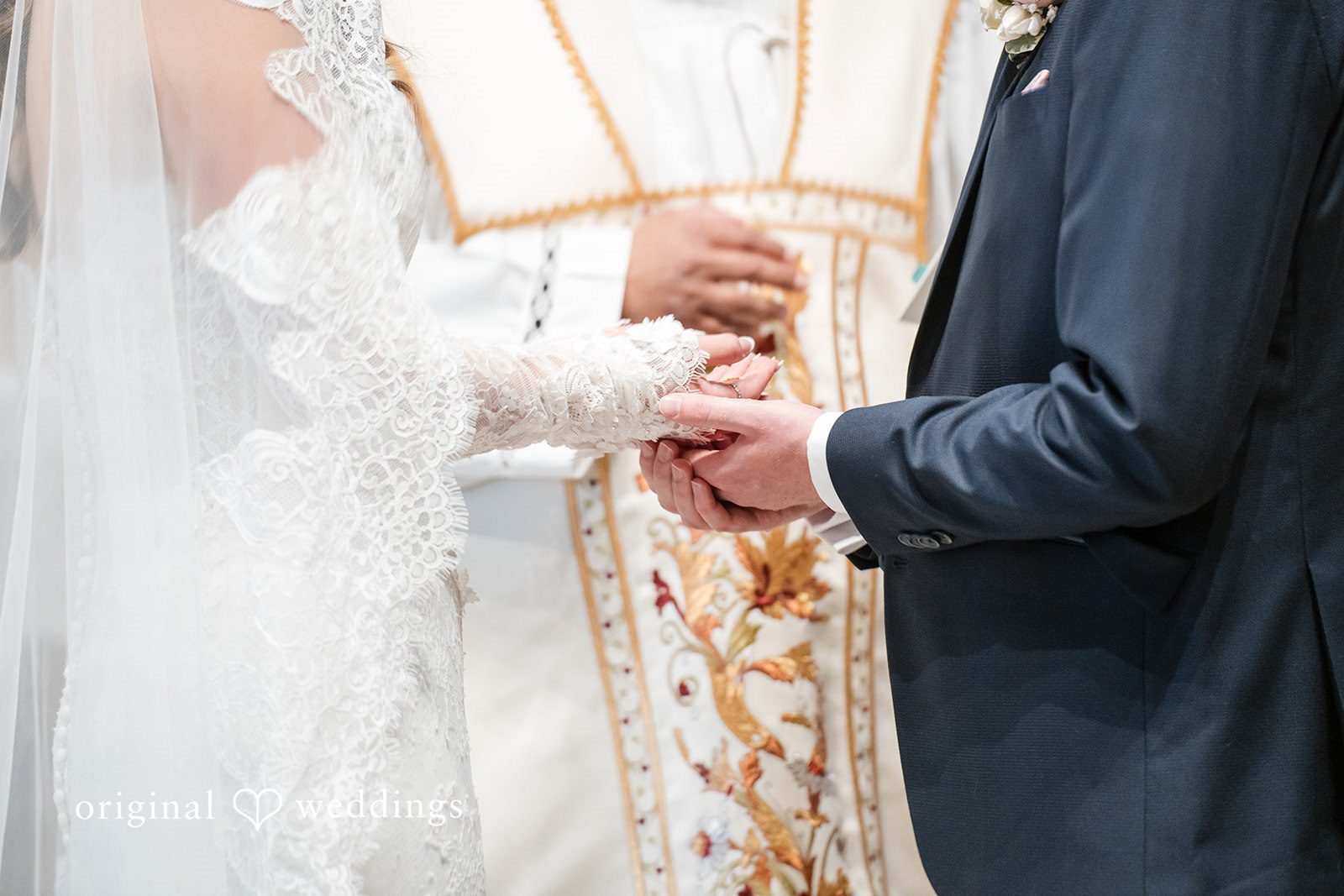 Maya + Max A close-up of a bride and groom's hands as they exchange wedding rings during their ceremony.