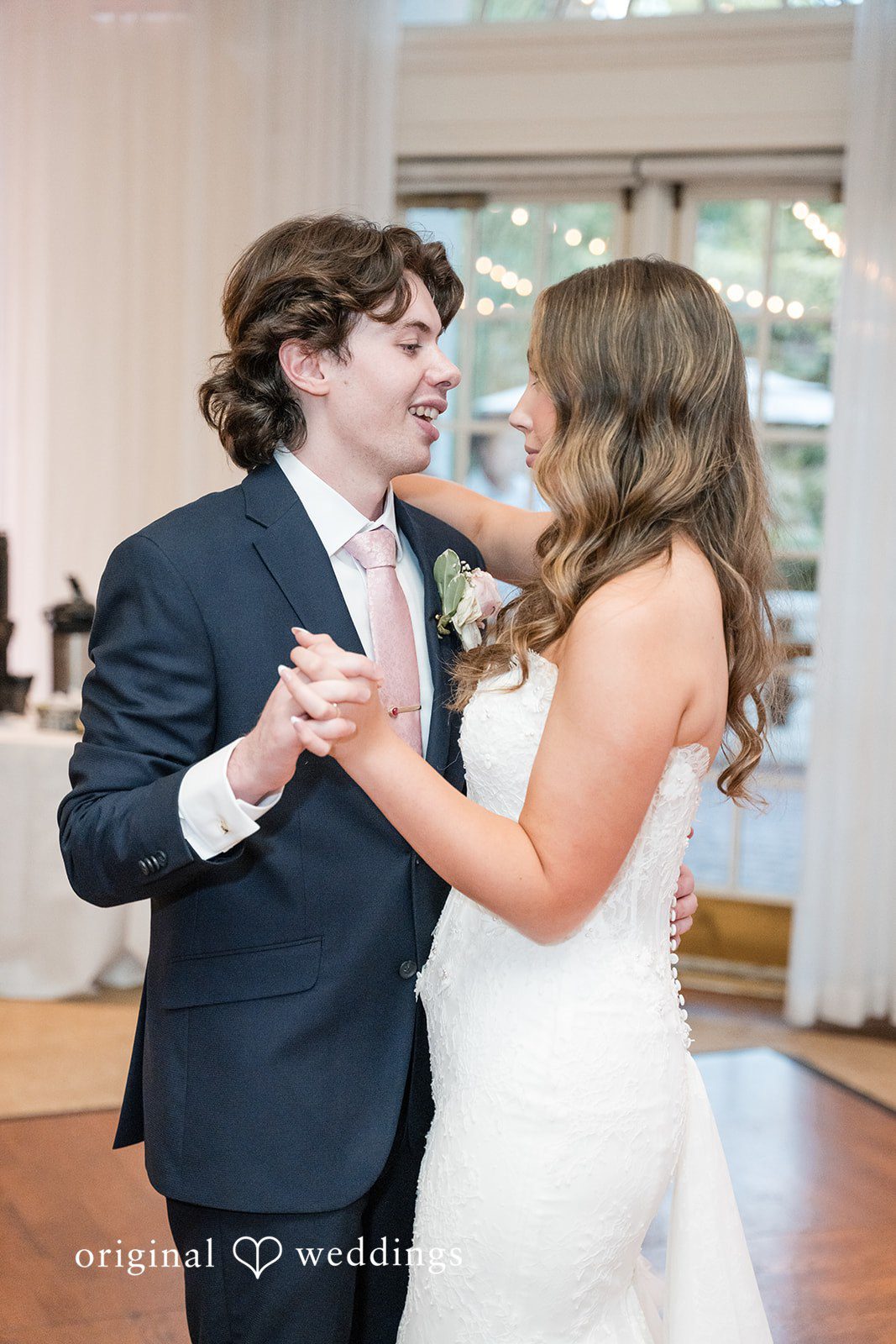 Maya + Max Bride and groom holding hands and smiling at each other during their first dance.