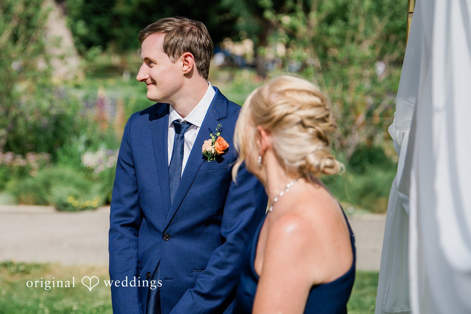 Sophia + Miles A groom in a blue suit looking affectionately at a bride.