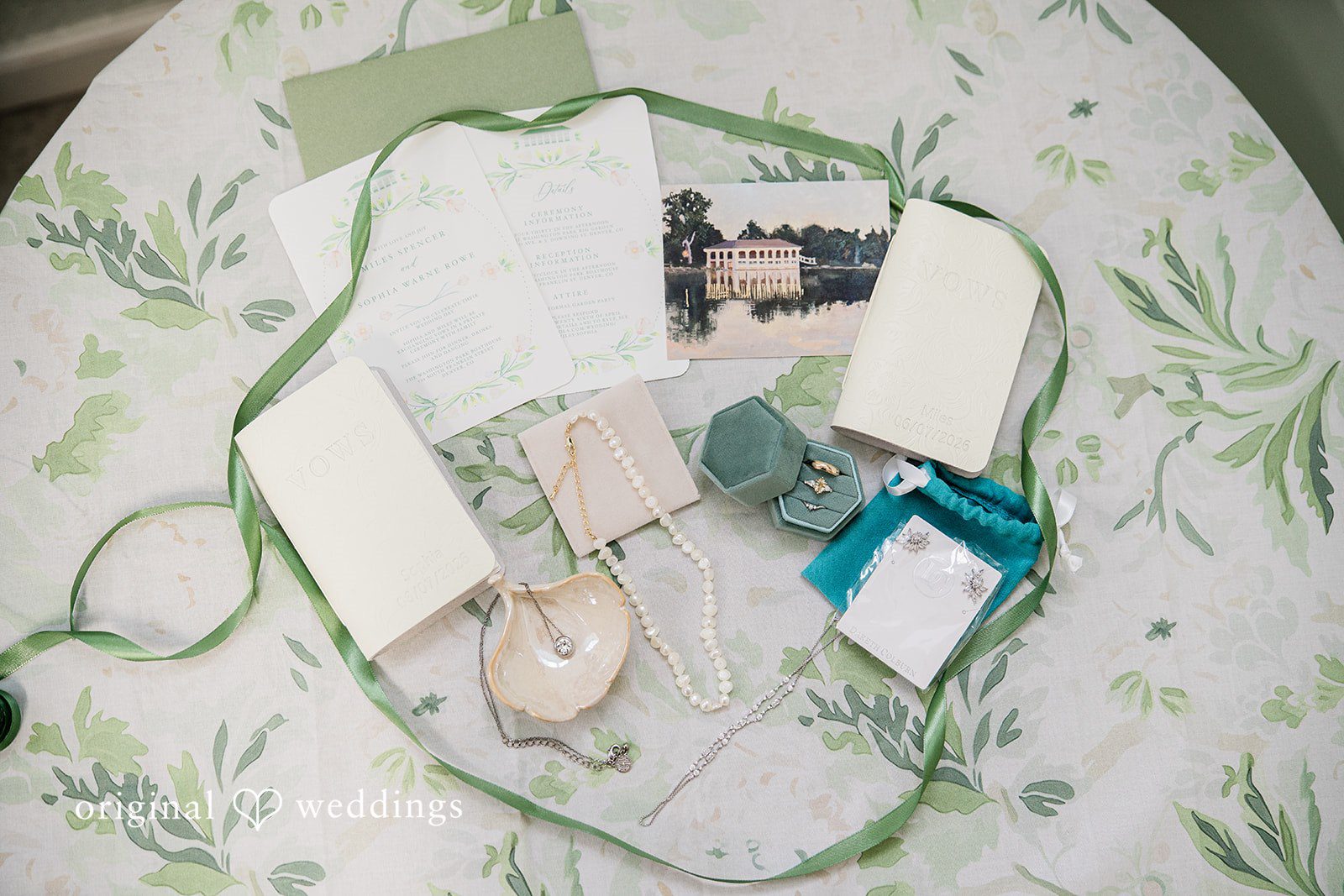 Sophia + Miles Flat lay view of a clear glass plate, white menu card, and eucalyptus greenery on a textured tablecloth.