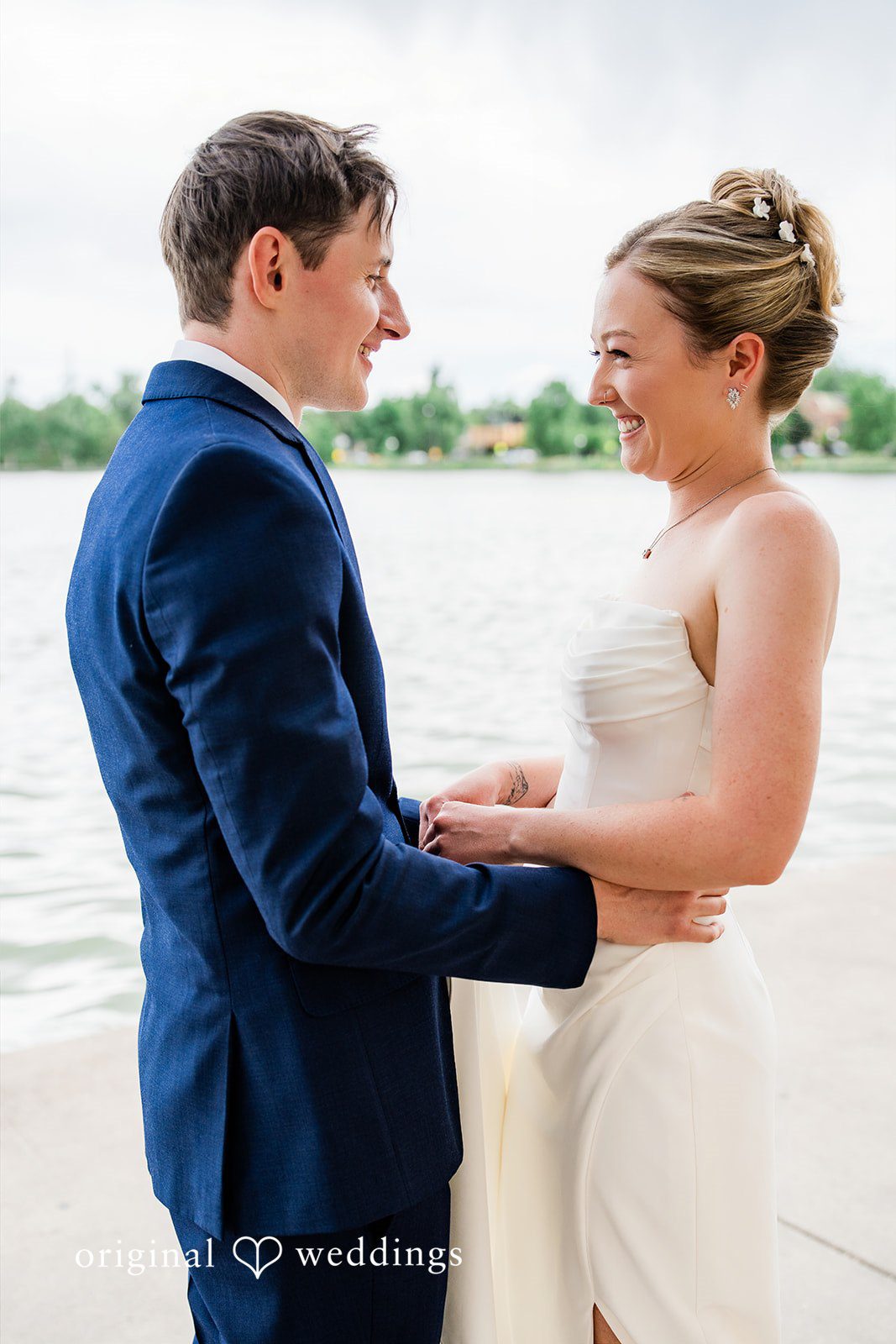 Sophia + Miles A cheerful bride and groom laughing and embracing at Washington Park Boat House.