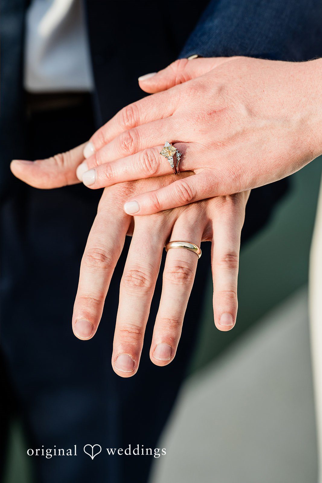 Sophia + Miles Close-up of a couple's hands showcasing their silver wedding rings.