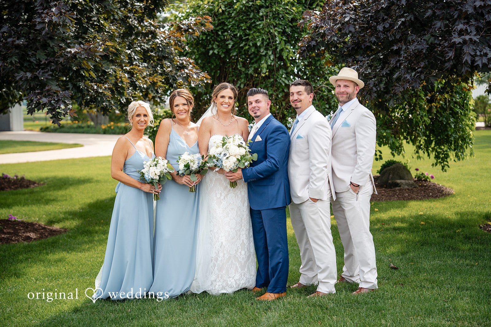 Bride and groom posing with bridesmaids and groomsmen outdoors