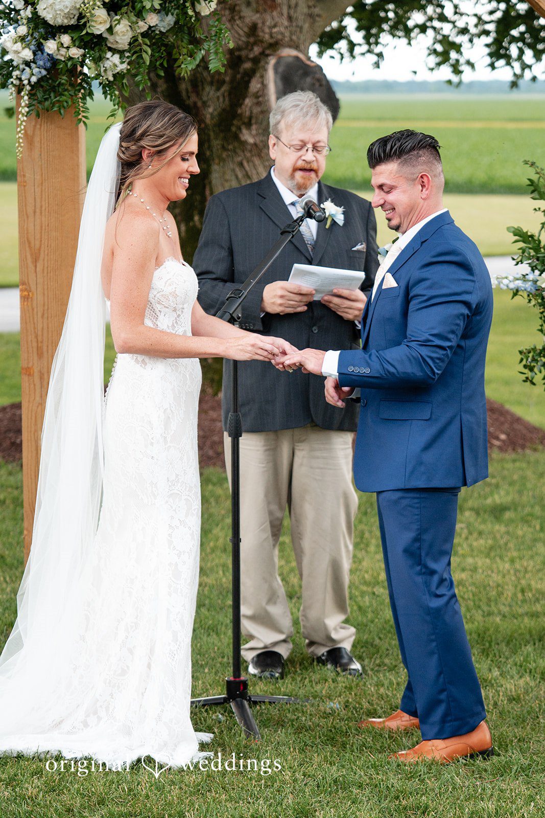 Bride placing the wedding ring on the groom during the ceremony.