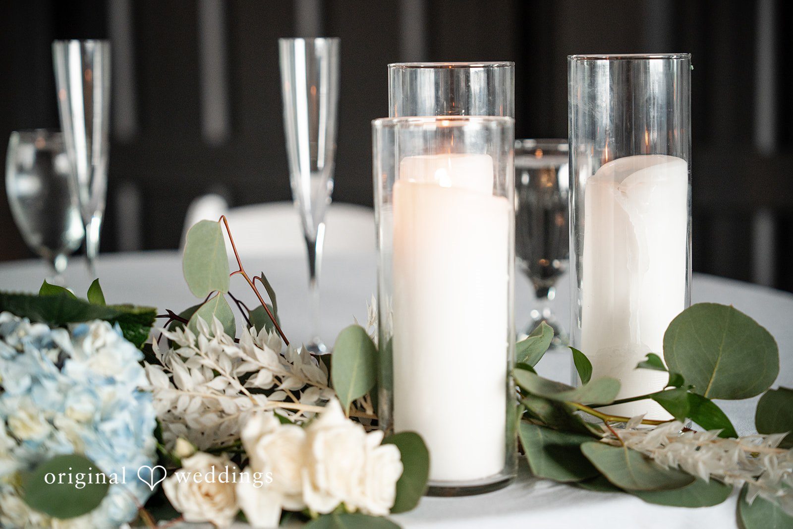 Elegant candle centerpiece with white flowers and eucalyptus at White Stone Events