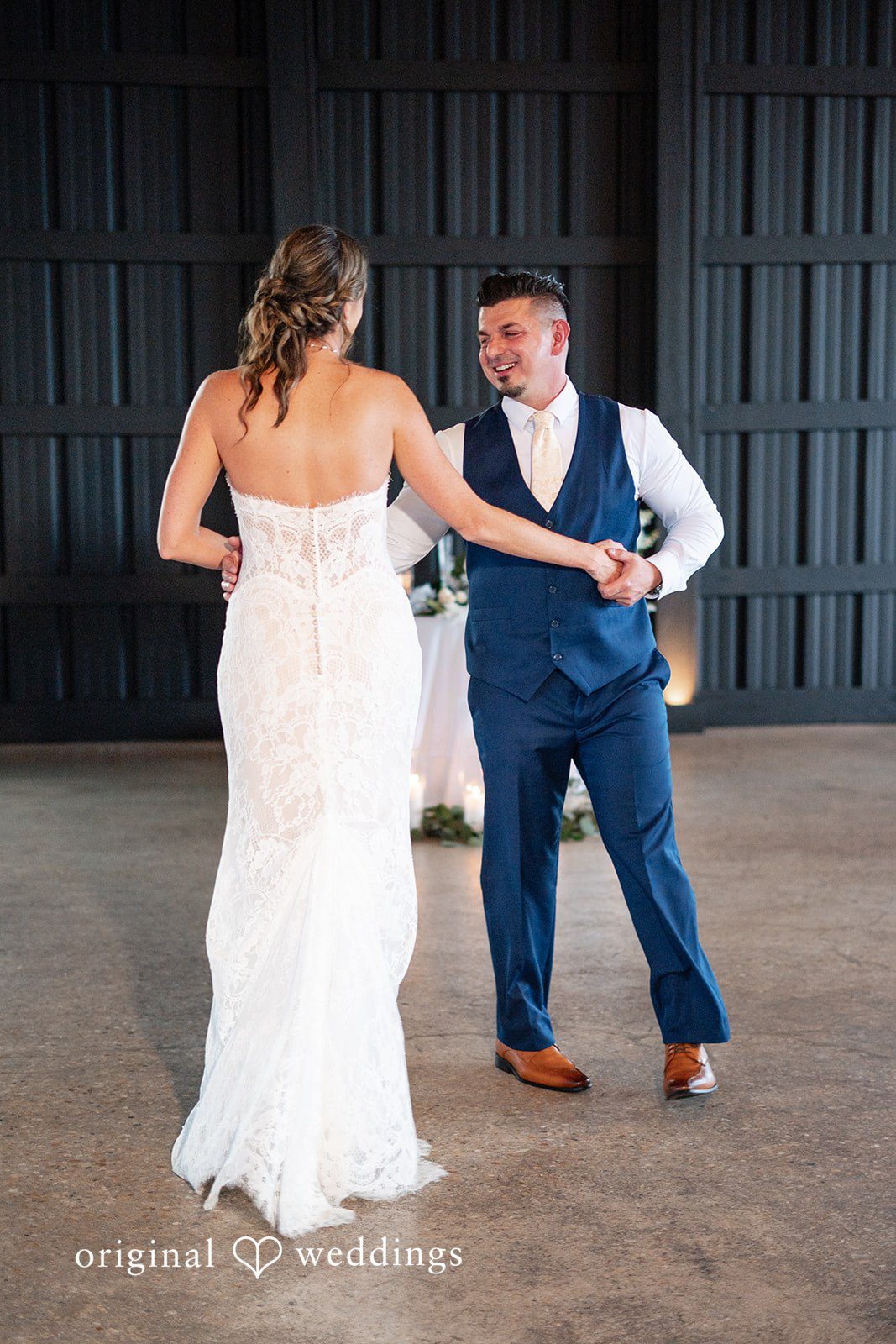 Newlyweds sharing their first dance surrounded by warm lighting.