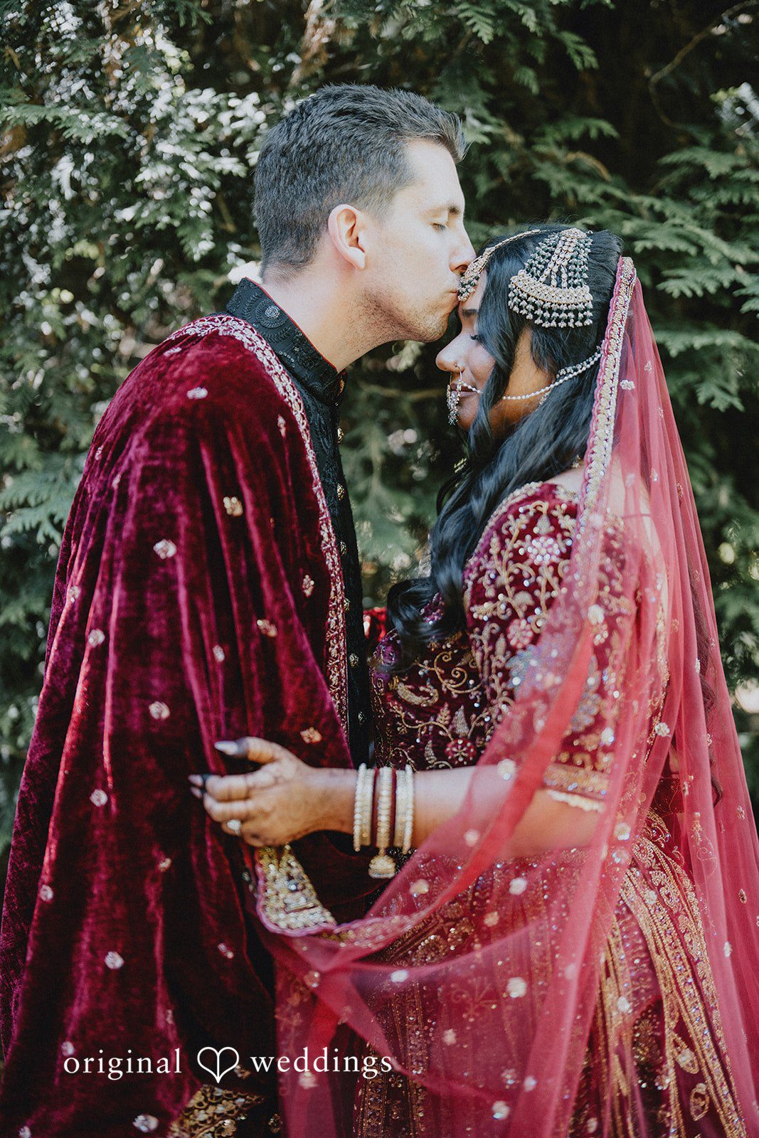 Groom kissing bride forehead with love at Willows Lodge