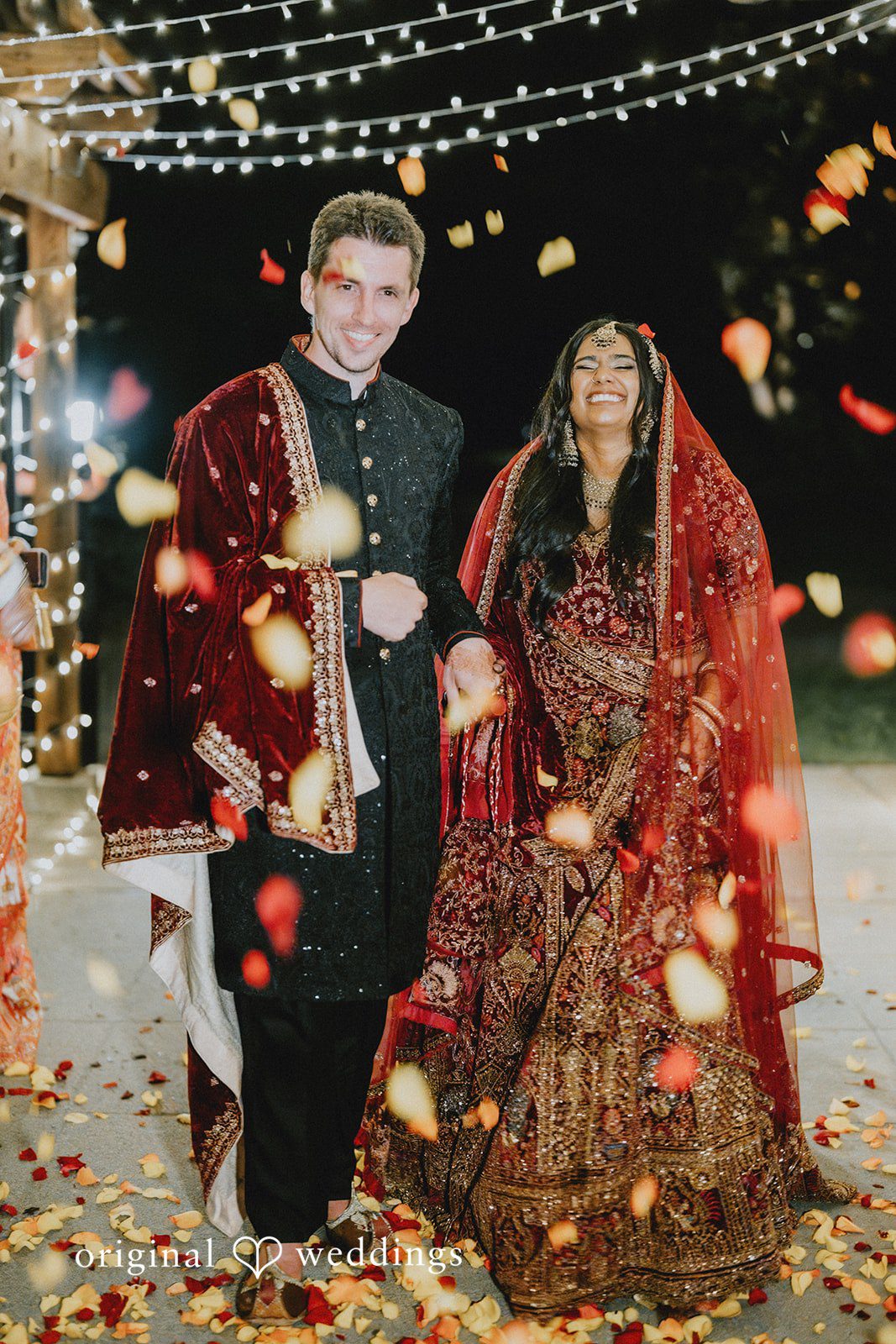 Bride and groom celebrating their wedding reception beneath twinkling lights at Willows Lodge