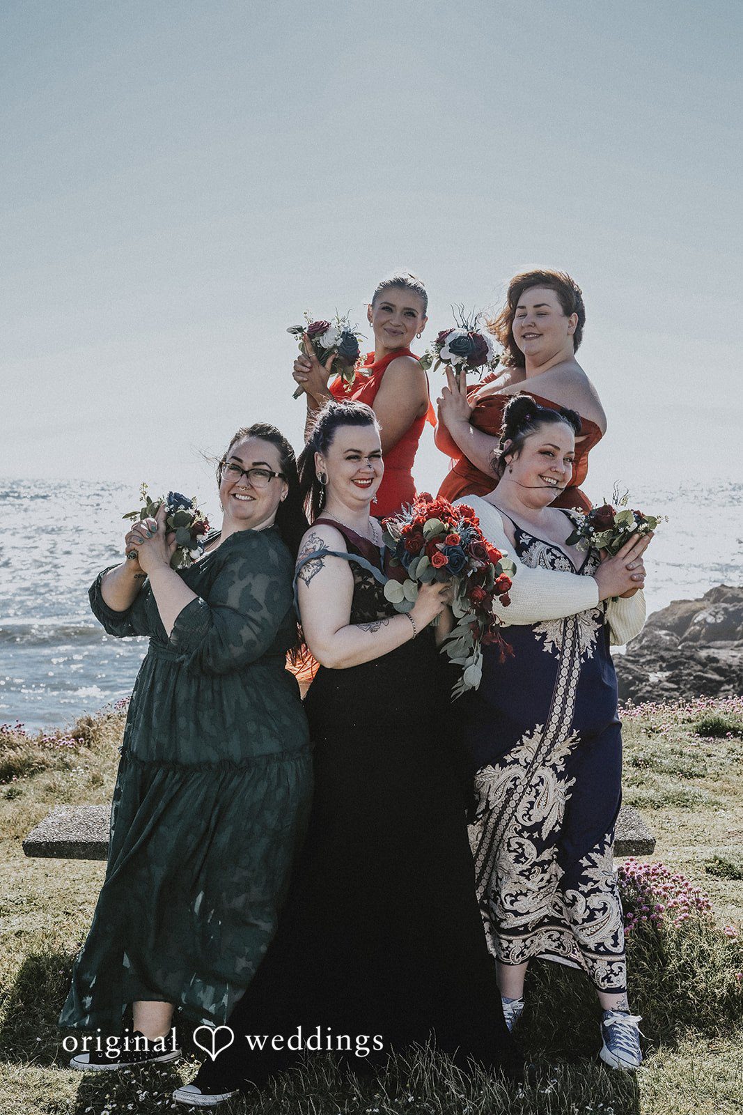 Group of wedding guests dressed in dark attire posing together.
