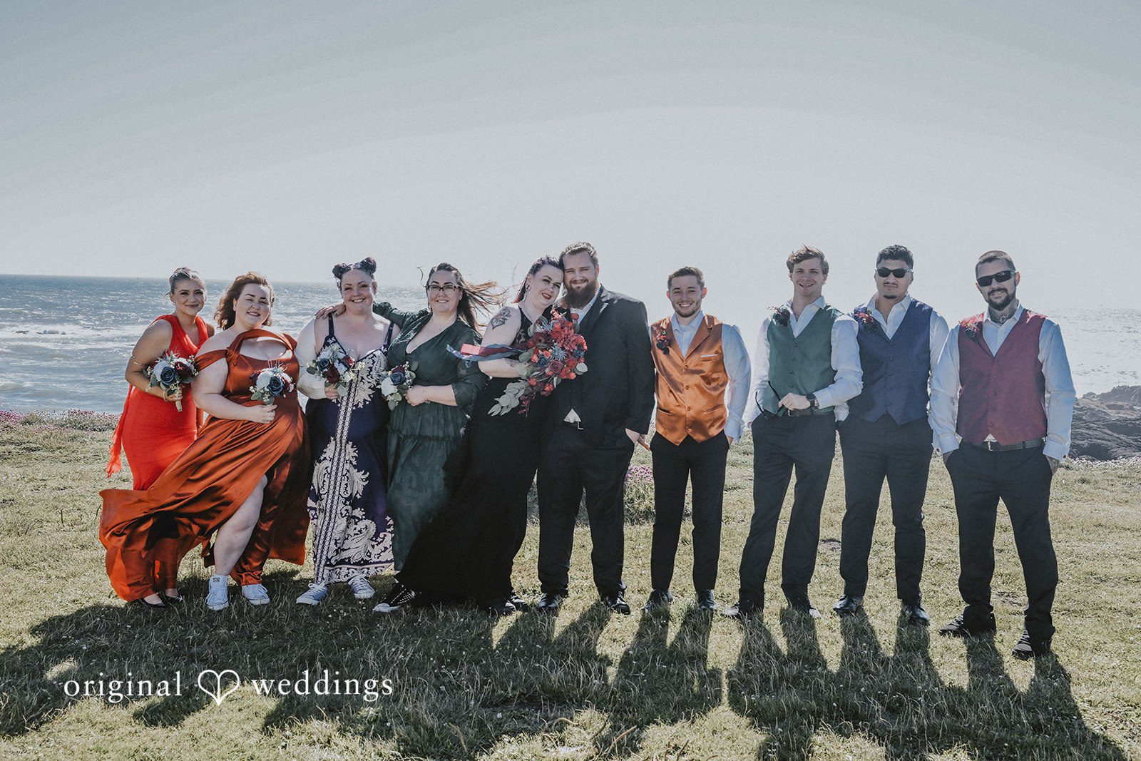 Full wedding party lined up horizontally for a group photo.