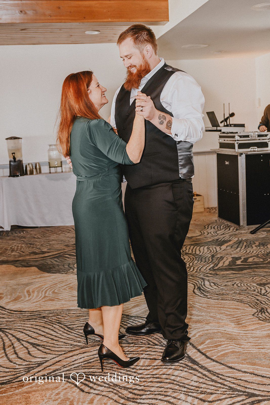 Groom dancing with a woman wearing a green dress.