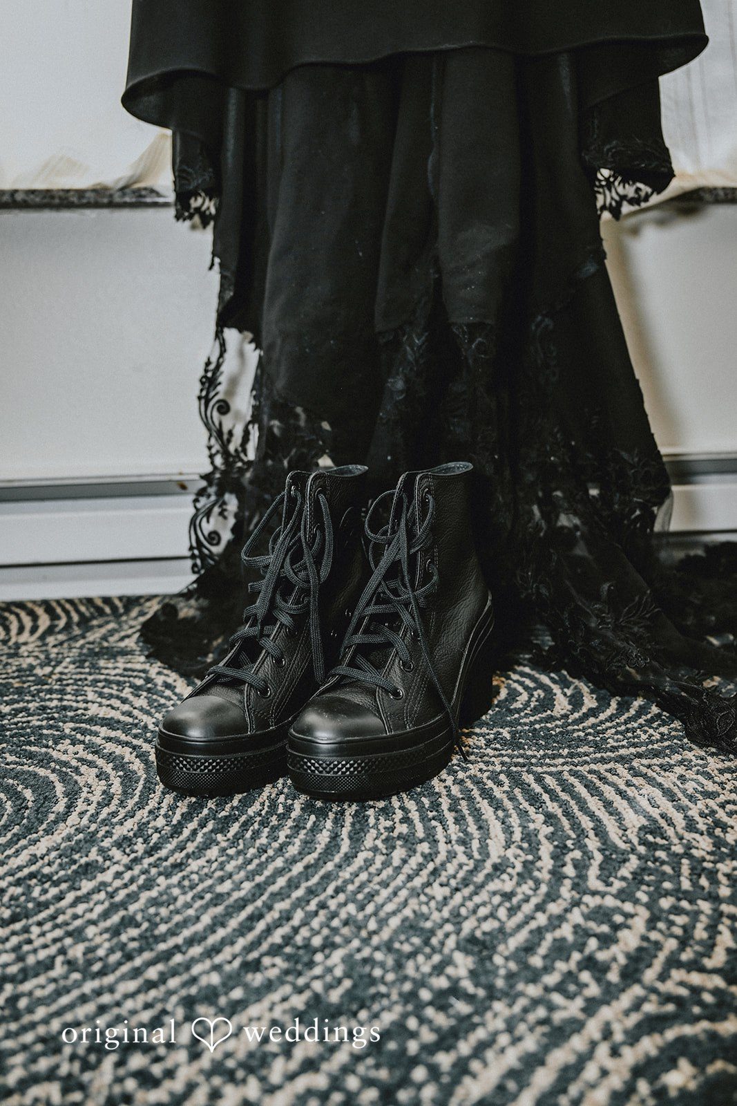 Close-up of black boots on a textured patterned rug.