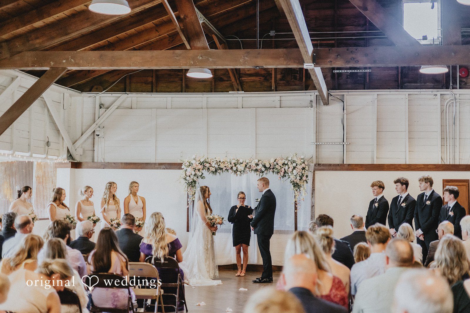 Emily + Ethan Wedding ceremony in progress with guests seated on both sides.