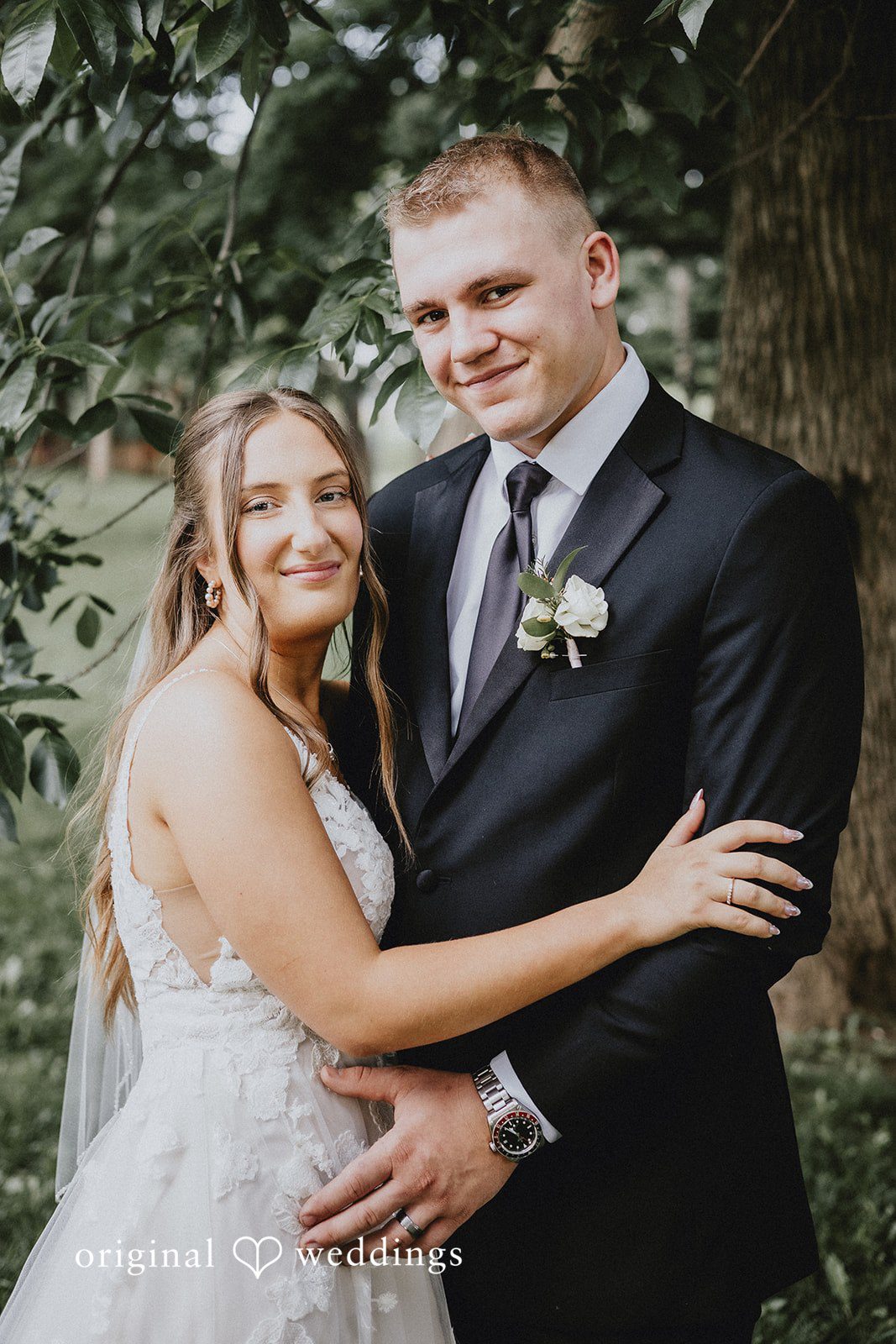 Emily + Ethan Close-up portrait of the smiling bride and groom holding each other.