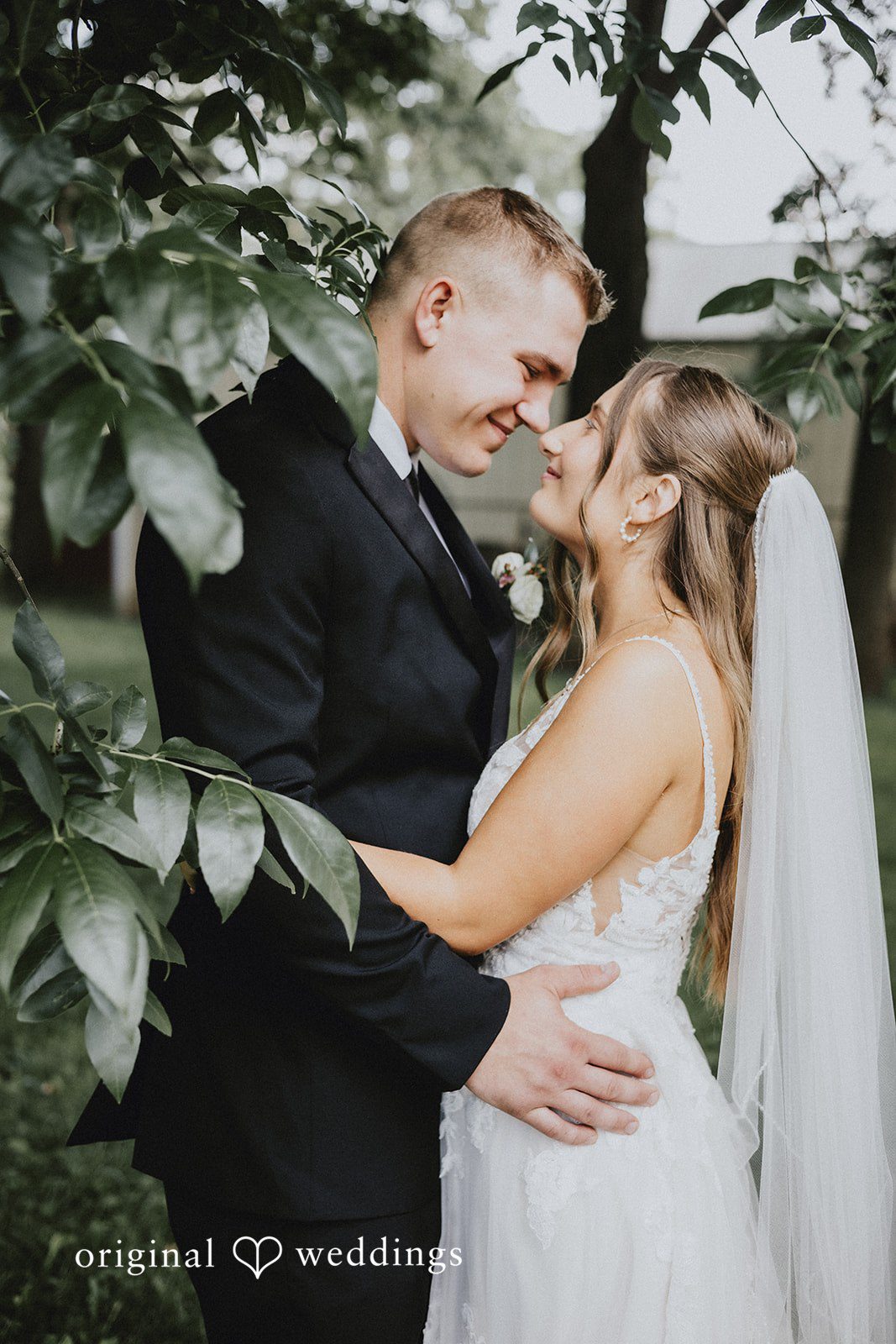 Emily + Ethan Groom leaning in toward the bride while embracing outside.