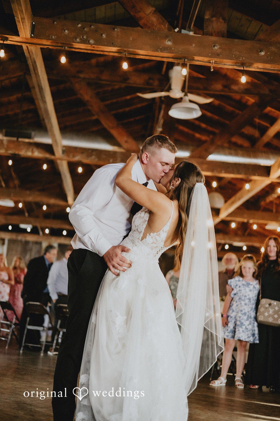 Emily + Ethan Bride and groom sharing a passionate dip and kiss on the dance floor.