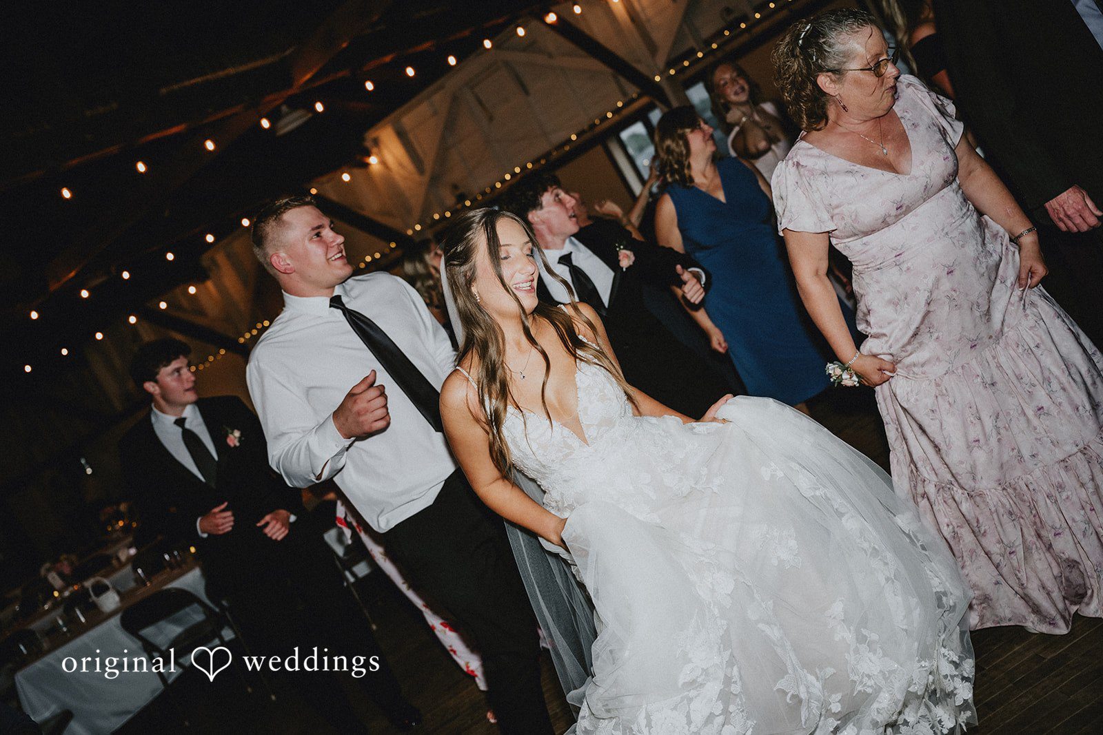 Emily + Ethan Bride and wedding guests dancing energetically on a lively dance floor.