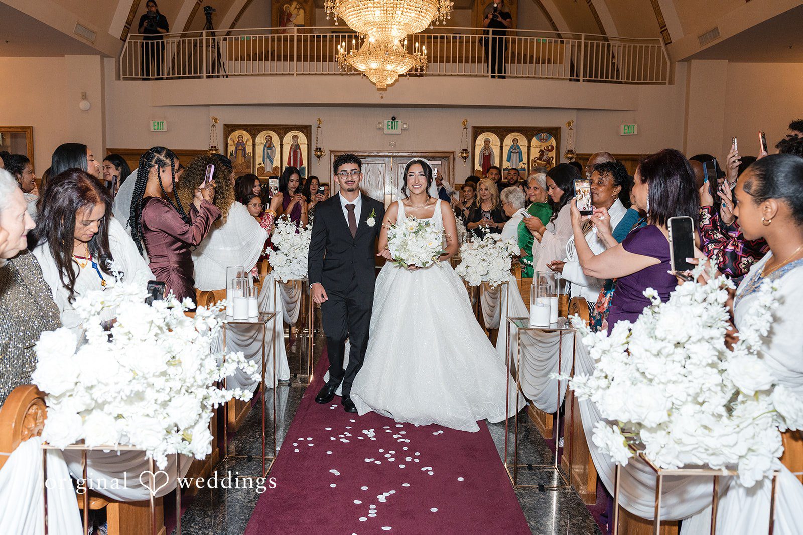 A wide view of wedding guests seated during a church ceremony.