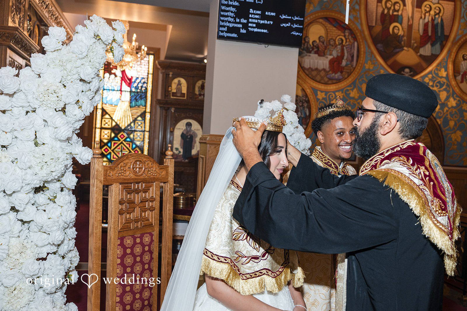 A priest performing ritual blessings over a bride and groom.