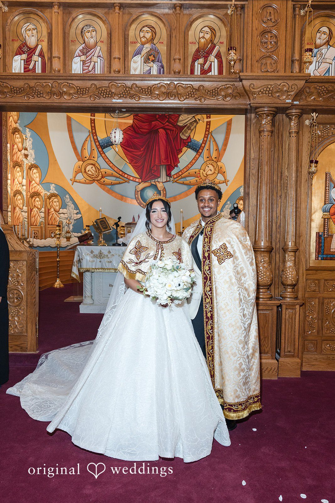 A bride and groom standing together at the altar with a priest.