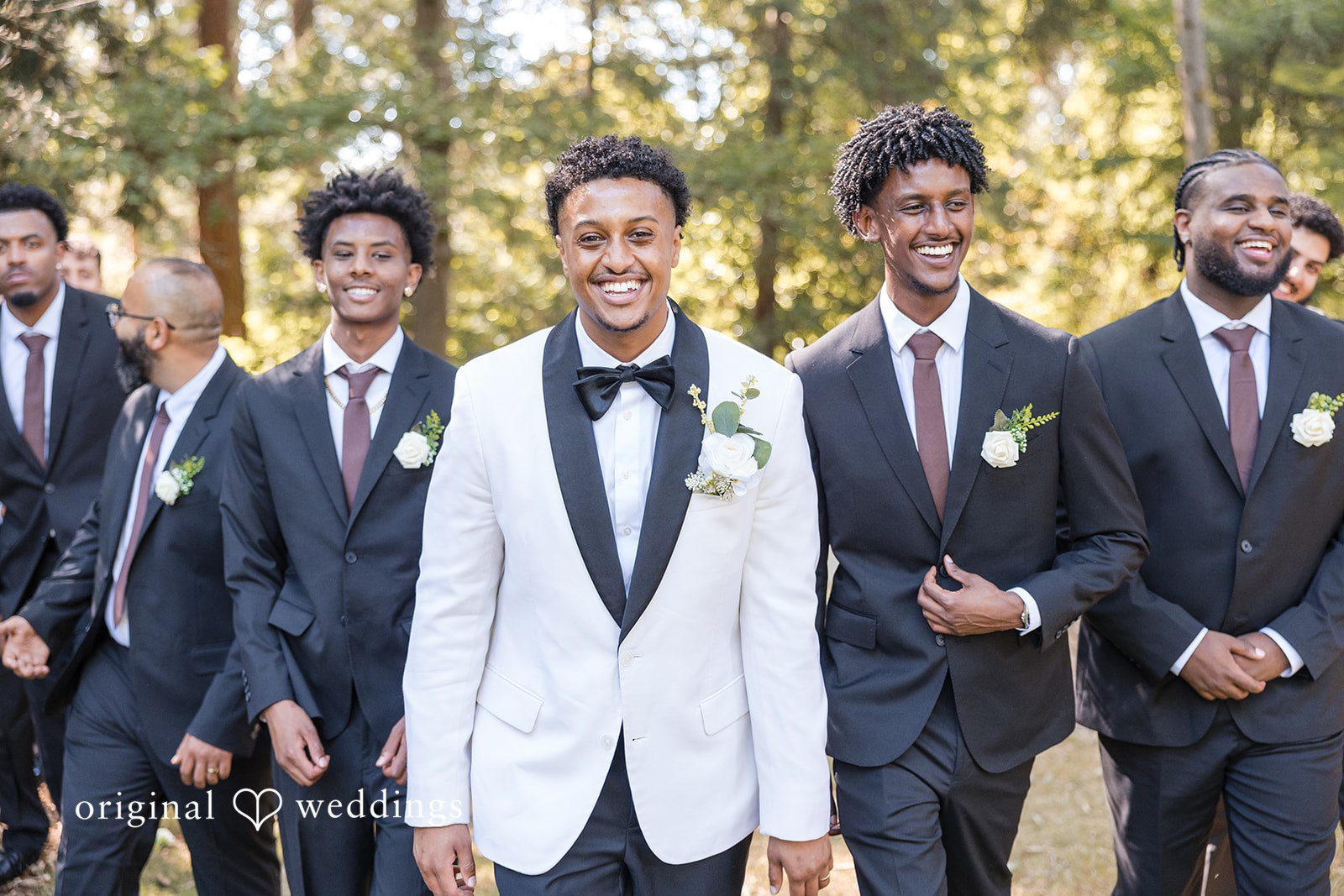 A groom standing shoulder-to-shoulder with a line of groomsmen.